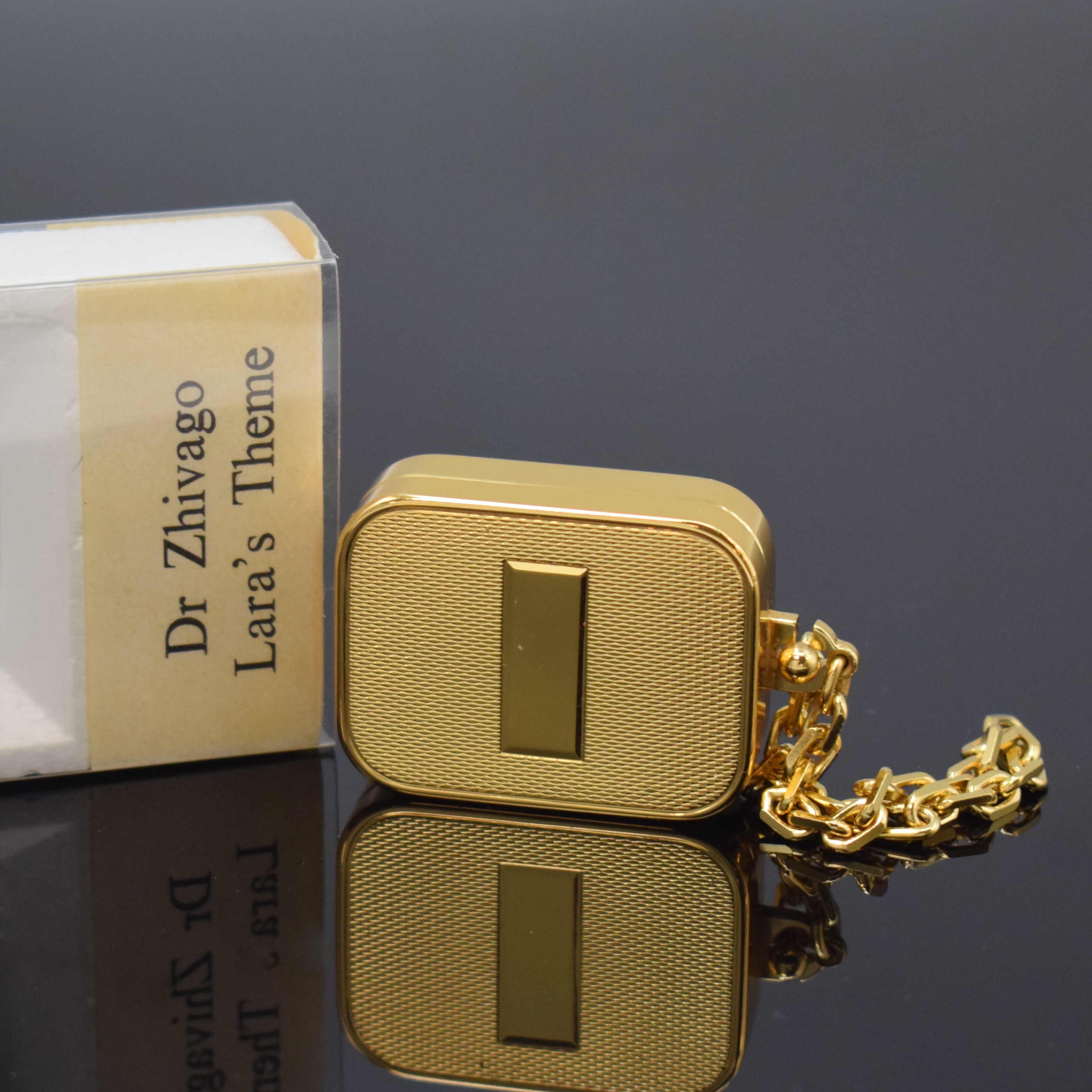REUGE Miniatur-Spieluhr, Schweiz um 1970, Melodie "Lara`s Lied/Dr. Zhivago", verg. Geh. m. Kette, Walzenspielwerk, Auslösung durch ...