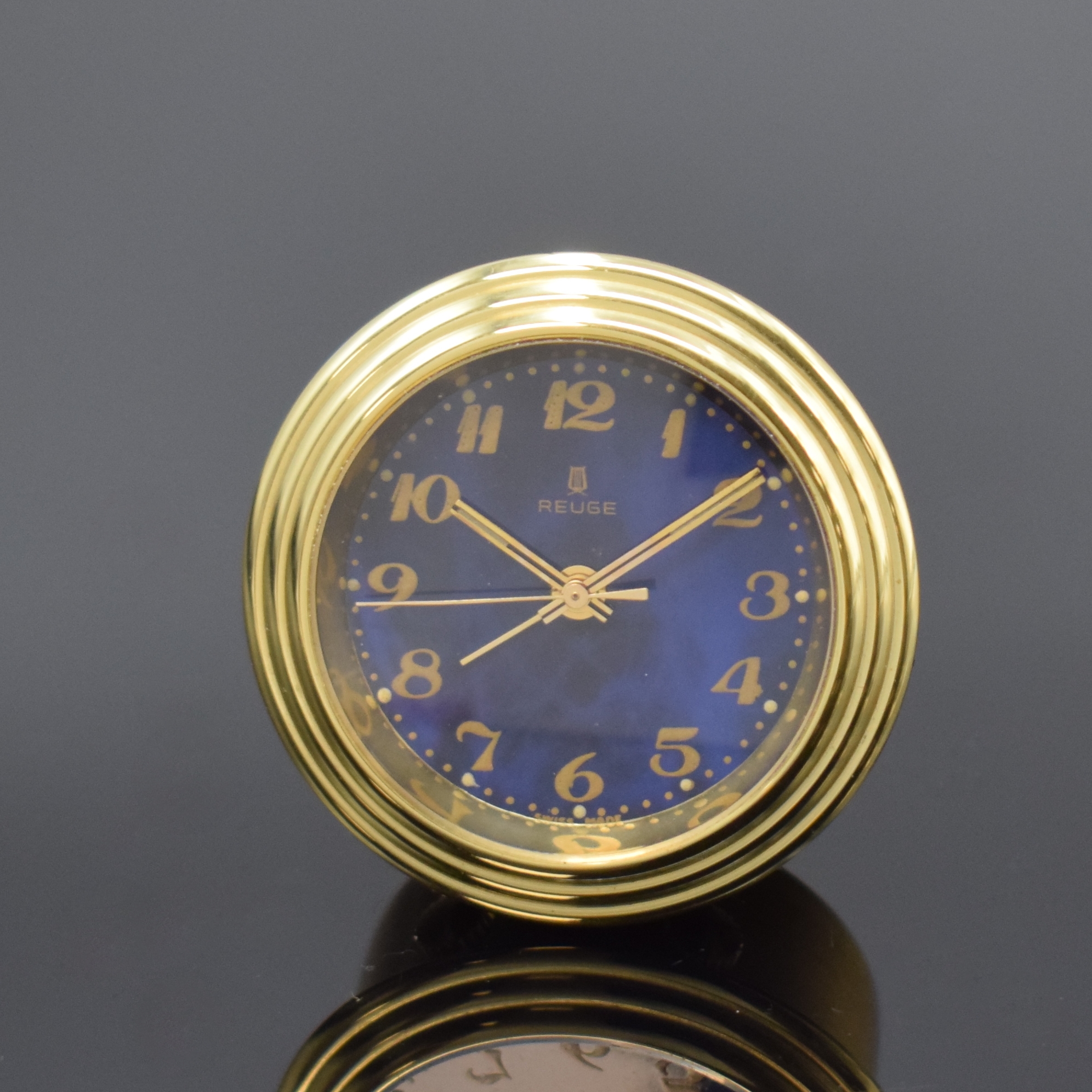 REUGE kleiner Tischwecker mit Spieluhr, Schweiz um 1970, verg. Geh., blaues Zifferbl. m. arab. Zahlen, gold. Zeiger, Bedienung b. 5 u. 7 bzw. Aufzug ...