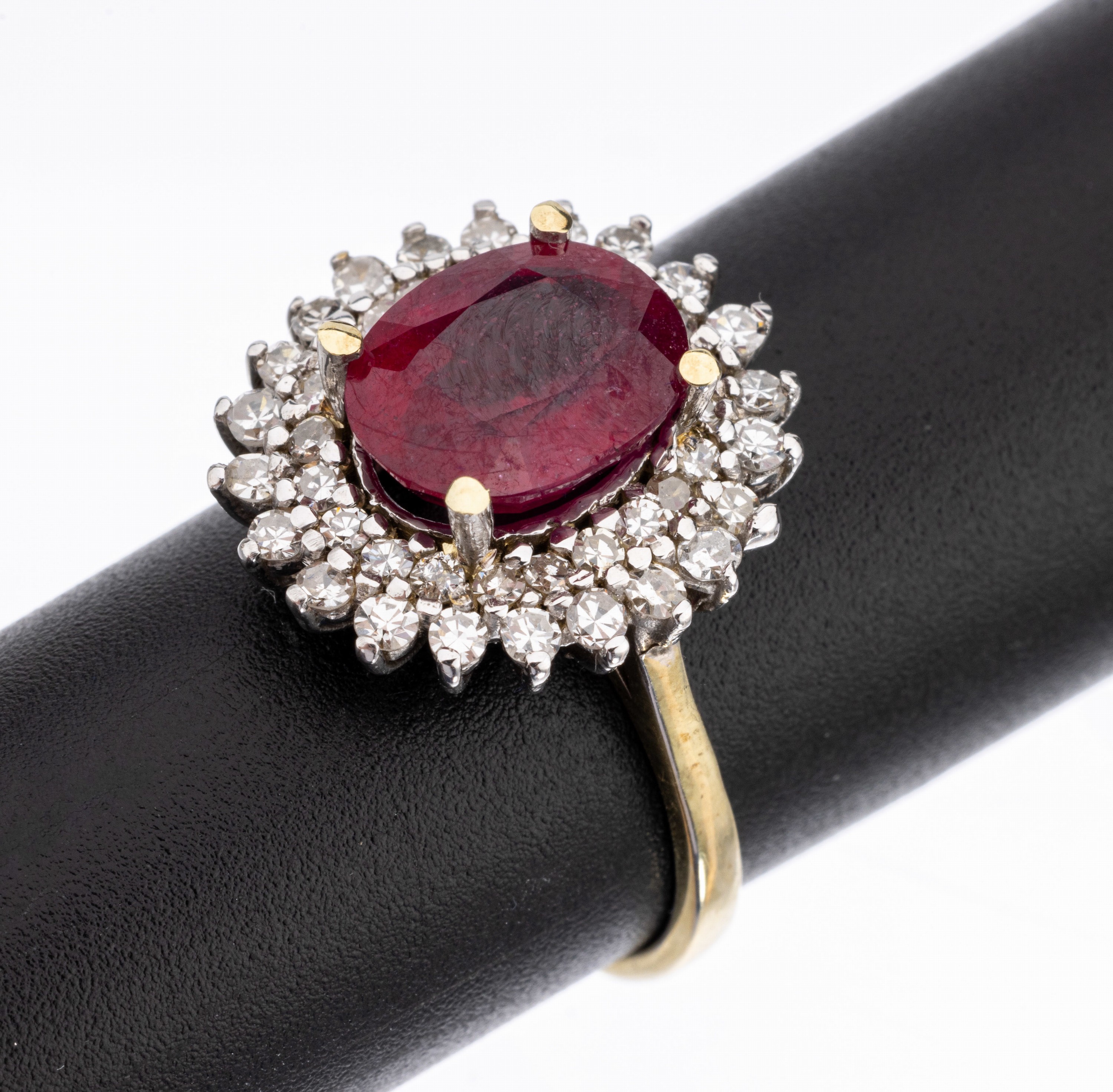 14 kt Gold Rubin-Diamant-Ring, WG/GG 585/000, Ringkopf in WG, mittig ovalfacett. Rubin (beh.) ca. 3.85 ct, umgeben von 2 Reihenmit insg. 44 ...