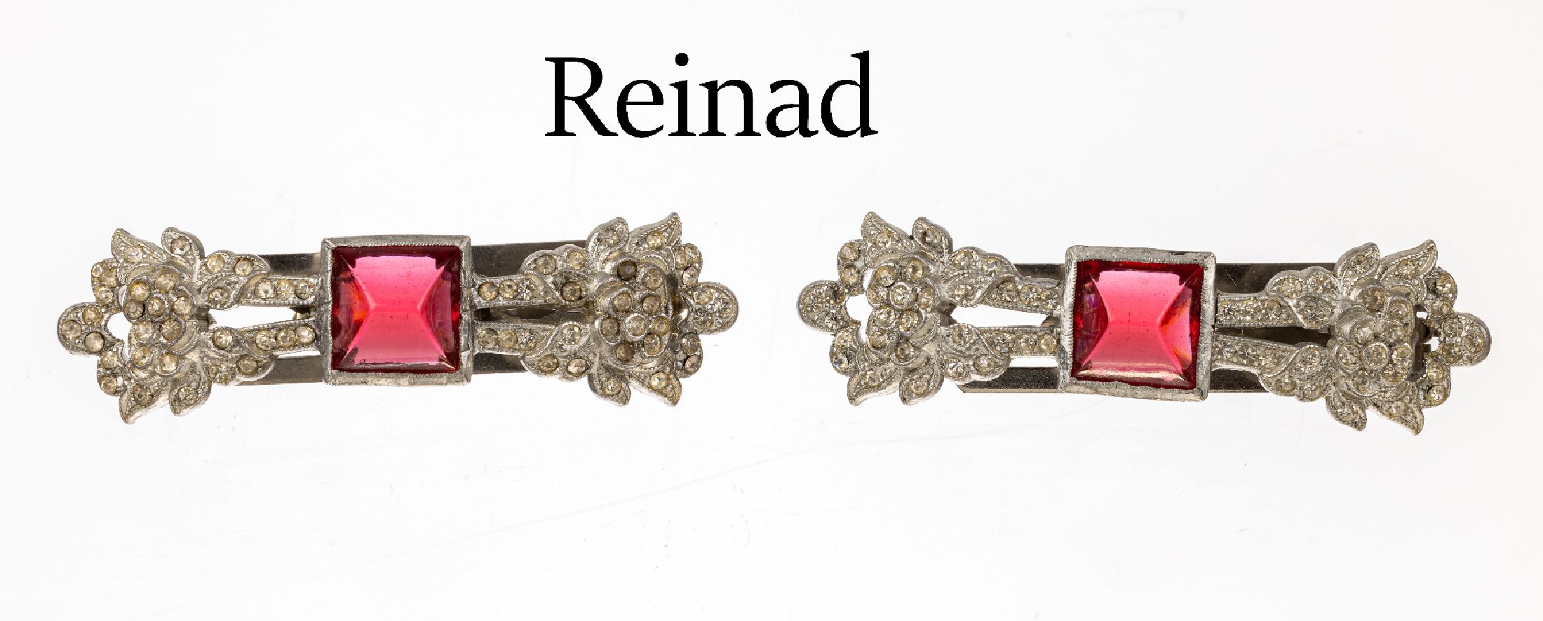 Paar Kragenclips, Reinad USA 1930er Jahre, Metall verchromt, farbloser und roter Straßbesatz, frühe Arbeit, L. ca. 6.5 cm, selten