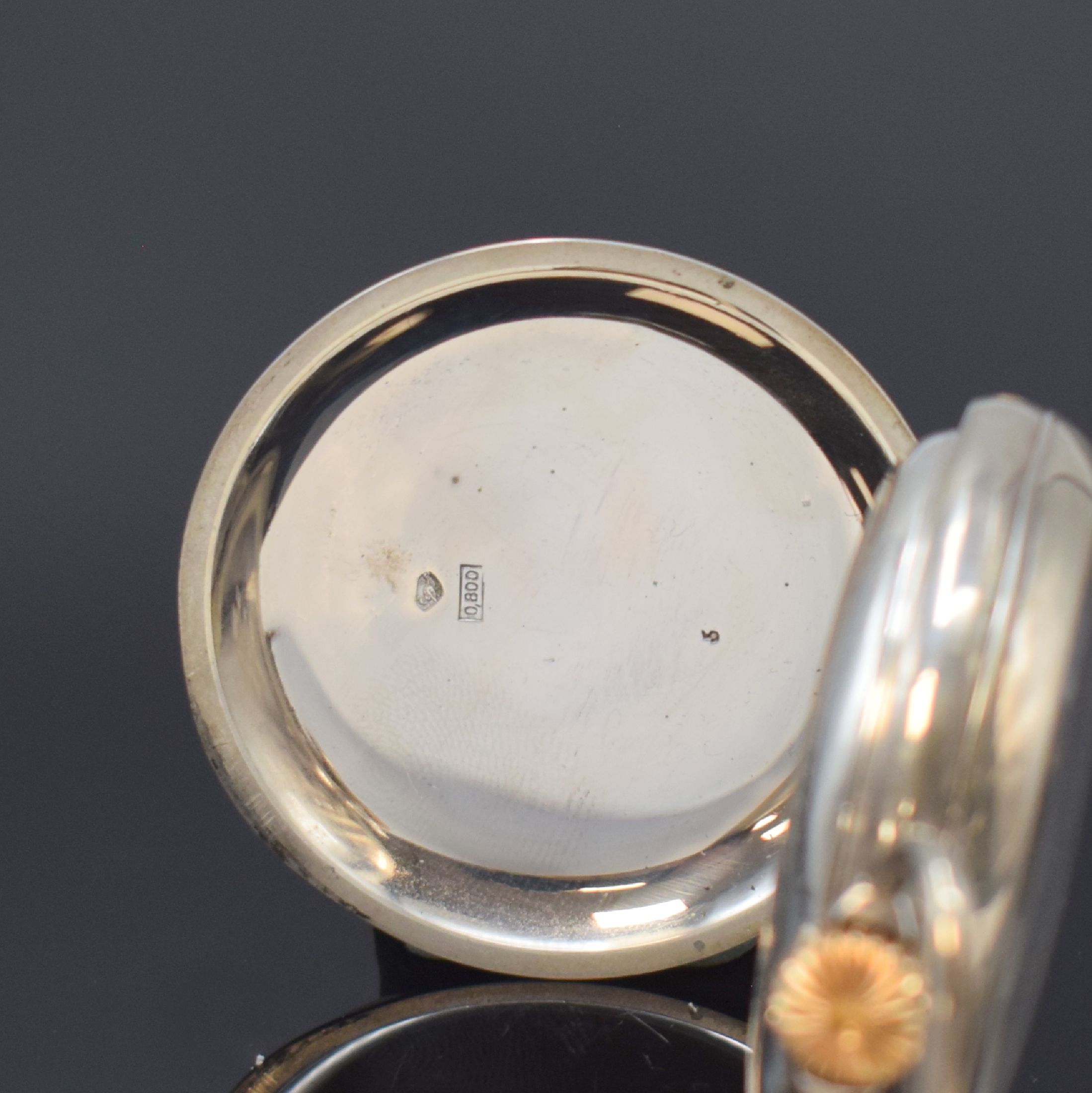 Detail b: Offene Kalendertaschenuhr in 800er Silber, Schweiz um 1910, Boden guill., gravierte Cuvette, Emailzifferbl. m. röm. Std., gebl. Zeiger, Anz. v. ...