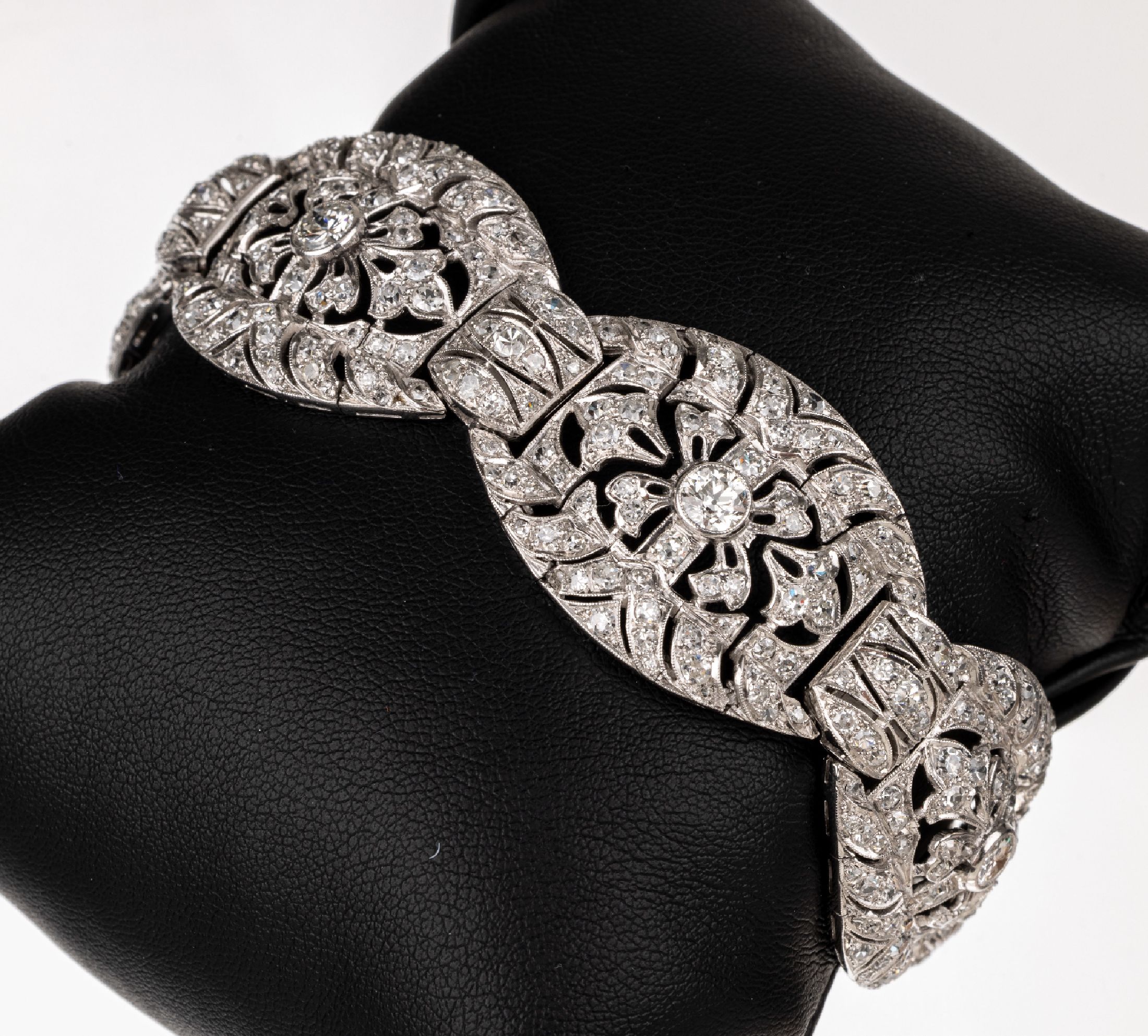 Platin Diamant-Armband, um 1920, Pt gepr., Glieder durchbrochen gearbeitet mit geschwungenen Elementen, Millegriffverzierung,mittig 5 ...