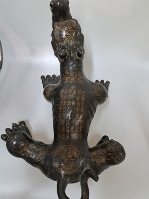 26723384b - Bronze sculpture of one of the Nine Dragons, China, late Qing/19th century, black patinated bronze, back and limbs with seal script in gold based on the model of the Han and Qing, probably depicting Chaofeng or Bian as sons of the Nine Dragons, rare form, rubbed, oxidized in spots, 28x48x36 cm; Provenance: from a German private collection, acquired from the Chinese art trade in 1998
