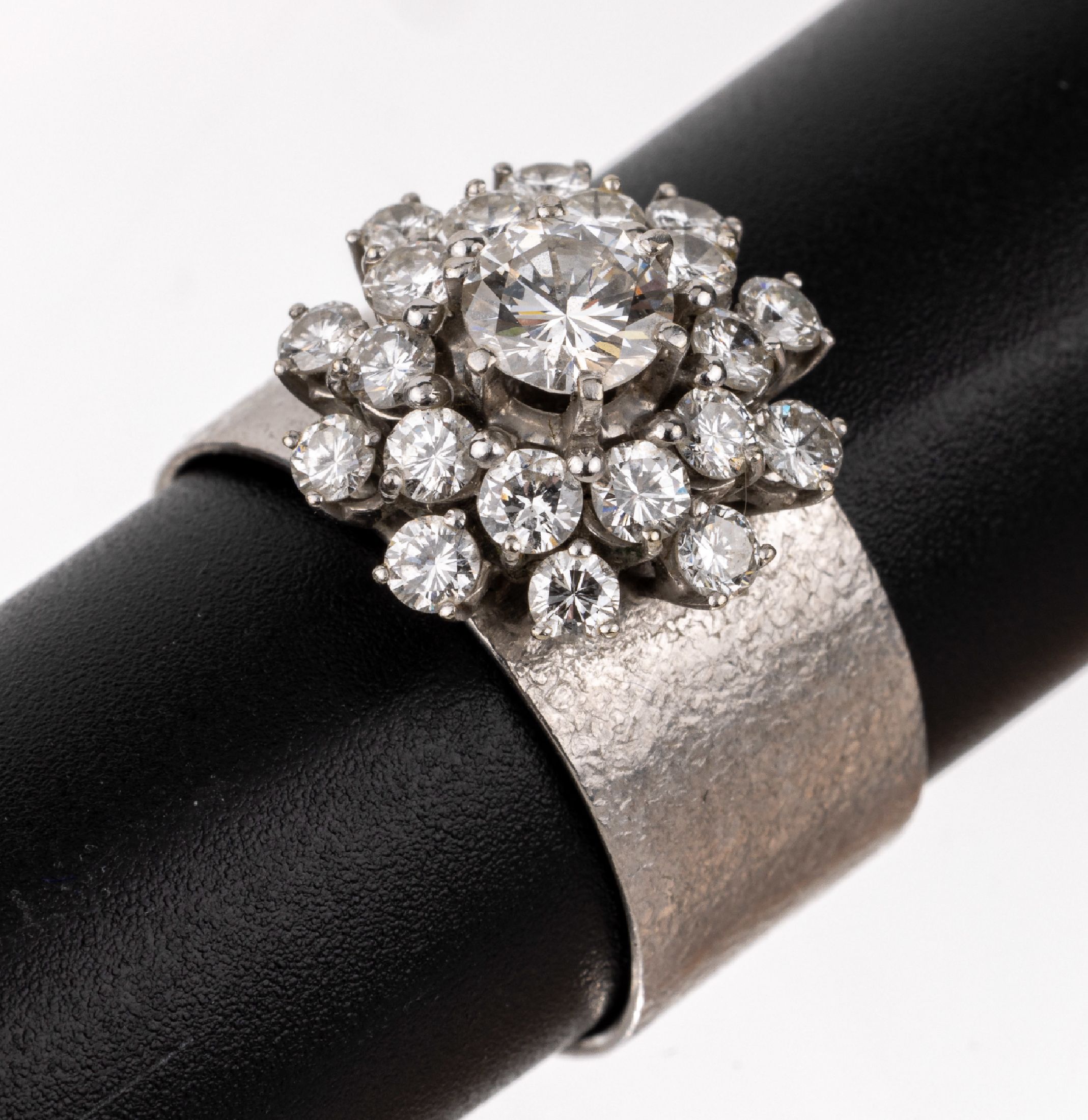 18 kt Gold Brillant-Ring, WG 750/000, sat.,1 Brillant ca. 0.65 ct Weiß/p, 20 Brillanten zus. ca. 1.00 ct Weiß/si, Meistermarke Wöhler,Mannheim, ...