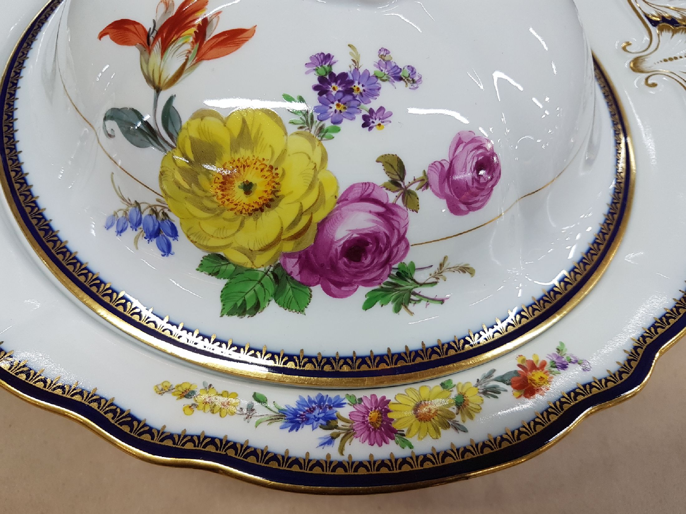 Detail i: Ragoutschüssel, Meissen, Pfeifferzeit, um 1924-33, 1. Wahl, A-Kante in kobaltblau und Gold, Goldstaffage, feine bunte Blumenmalerei, ca. 15x33x26cm