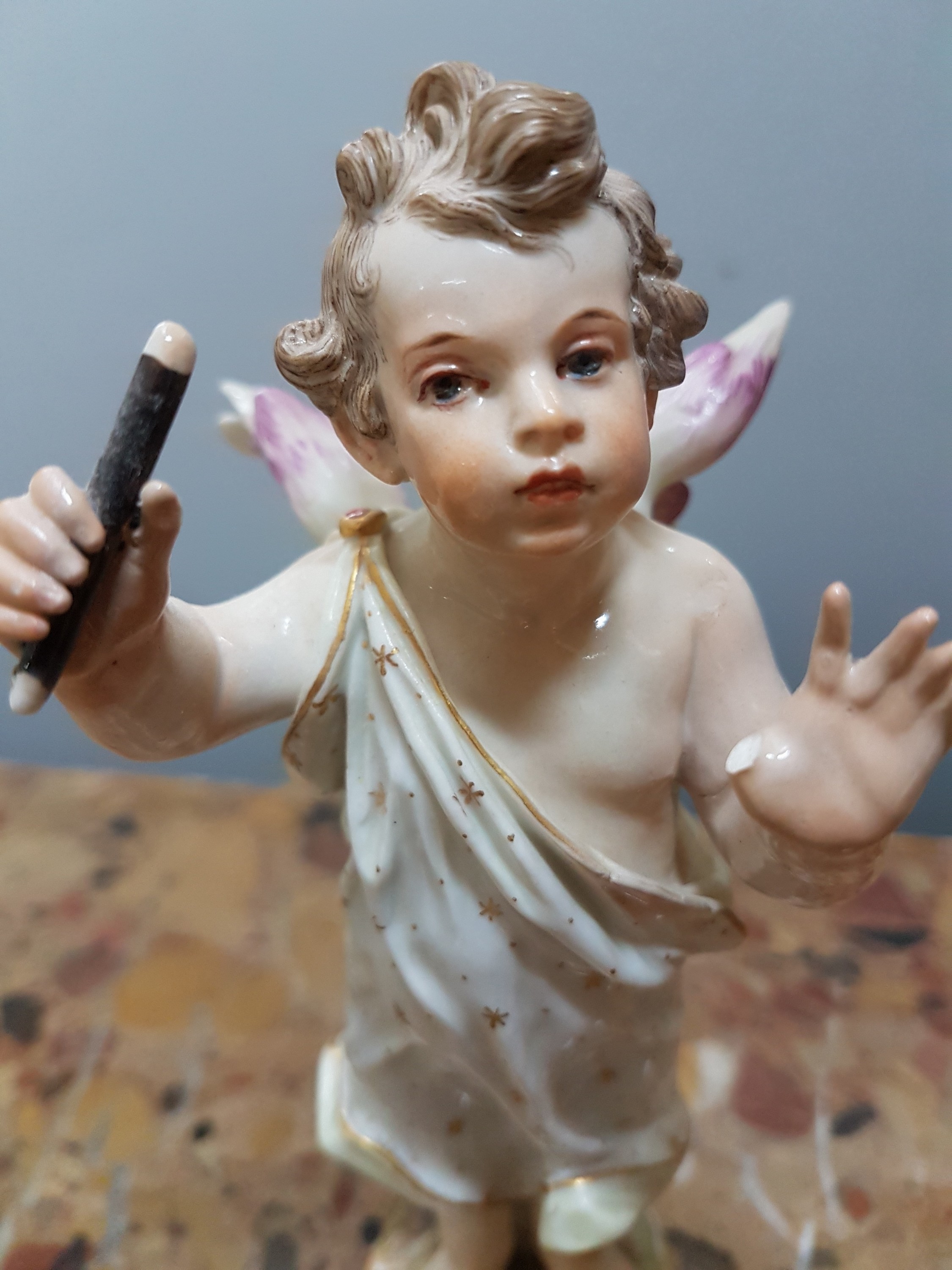 Detail e: Porzellanfigur, grüßender Amor, Meissen, um um 1900, Entwurf August Ringler, Modell-Nr. O 191, Daumen fehlt, Goldstaffage, H. ca. 18cm, Malernummer ...