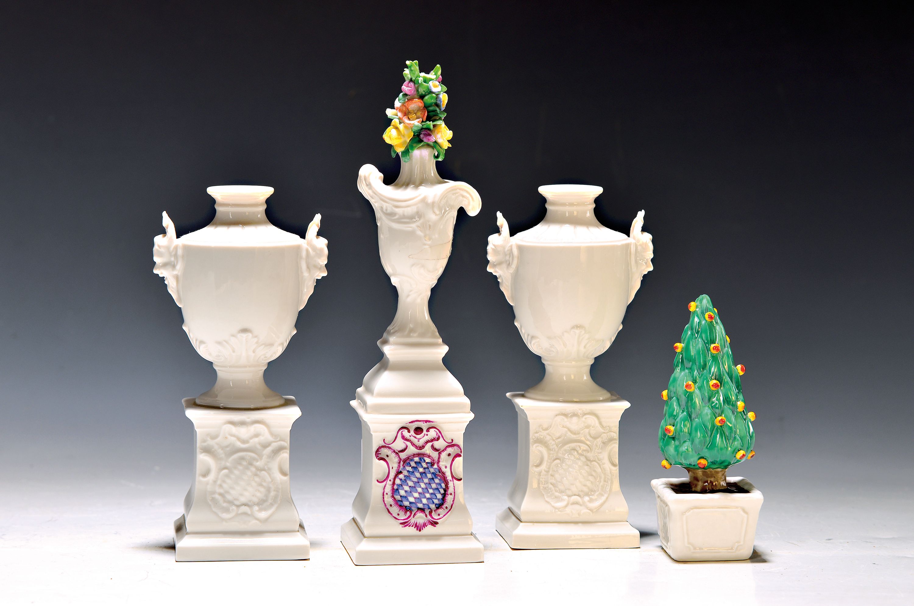 4 Teile Porzellan, Nymphenburg, 20. Jh., Miniaturvasenpaar auf Podesten mit bayer. Wappen, Maskerone an den Seiten, weiß, H. ca. 15cm; Ziervase auf ...