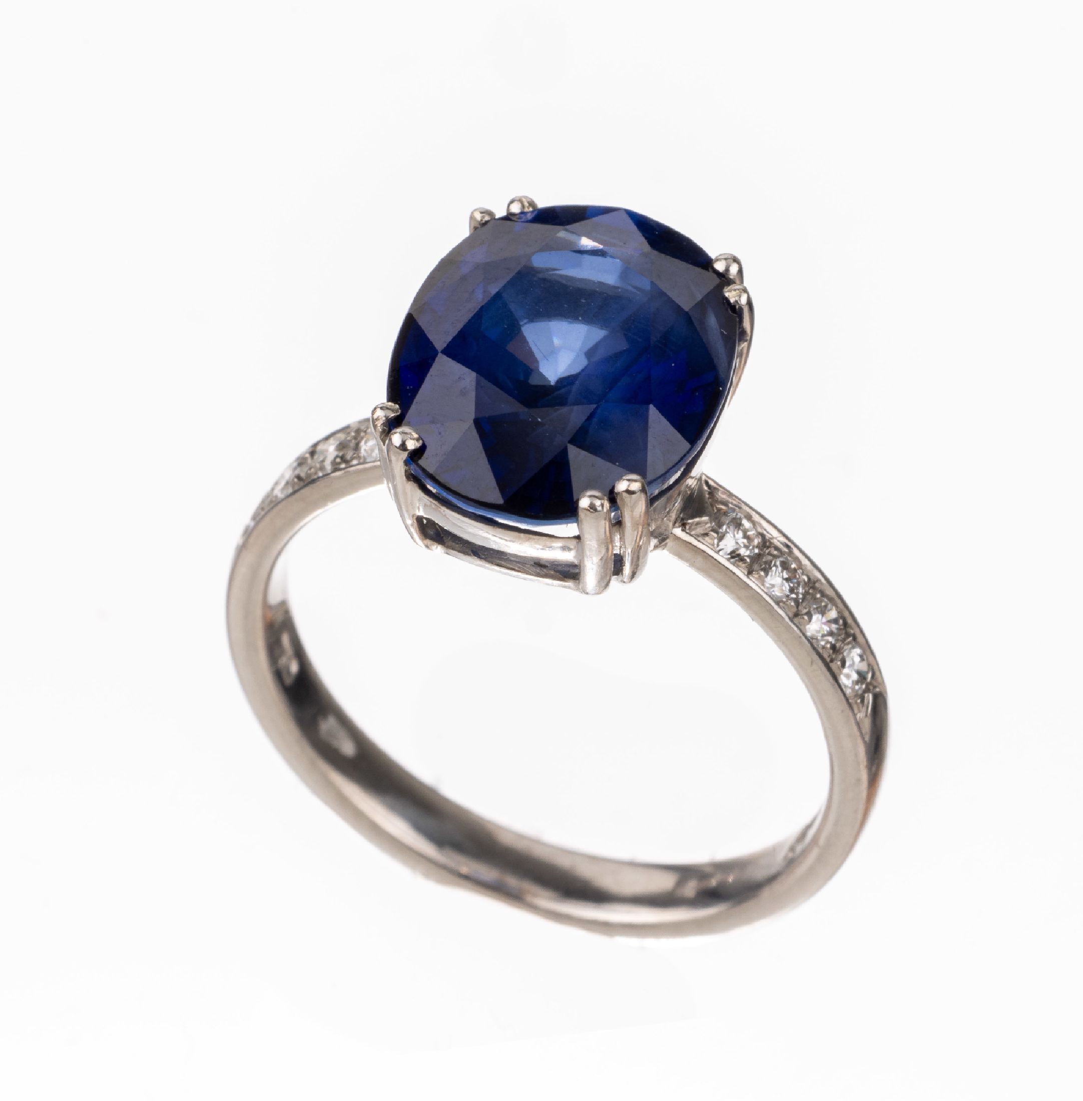 18 kt Gold Saphir-Brillant-Ring, WG 750/000, ovalfacett. Saphir 6.97 ct, 8 Brillanten zus. ca. 0.20 ct (grav.) feines Weiß-Weiß/vs, ca. 5.8 g, RW ...