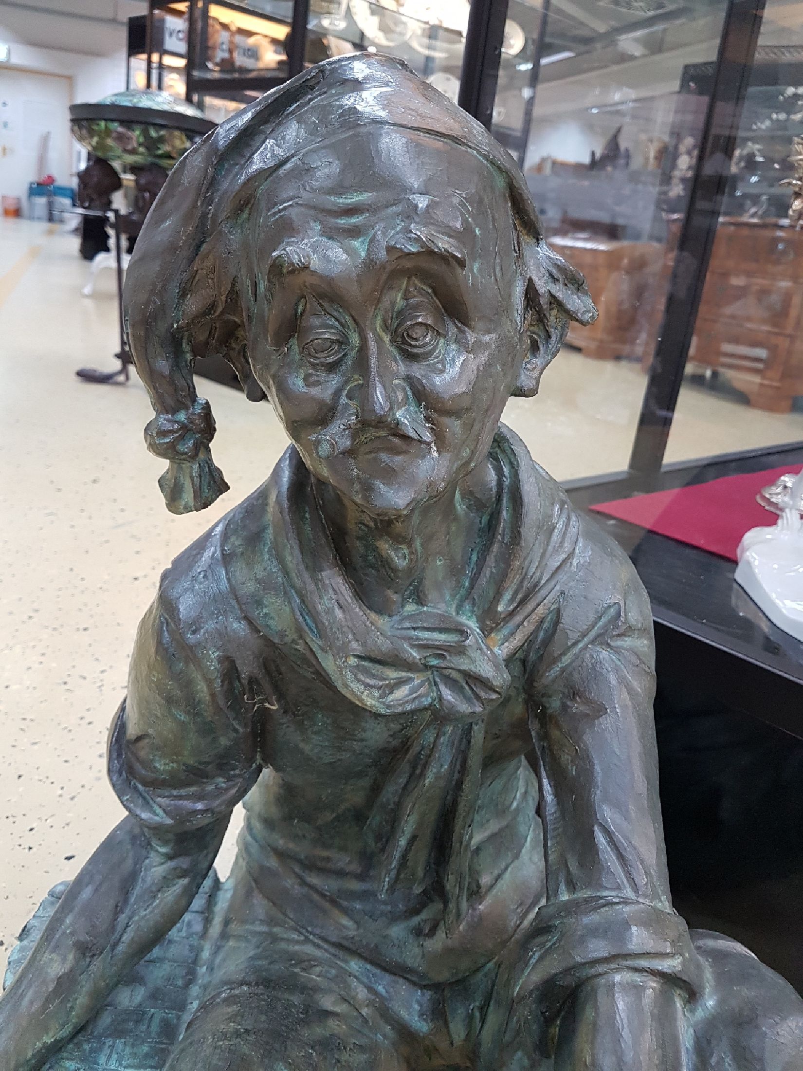 Detail a: Große Bronzefigur als Wasserspeier, wohl Rottenecker, sitzender Mann mit Korb und Fisch (aus dem dann das Wasser läuft), leicht karikierende ...