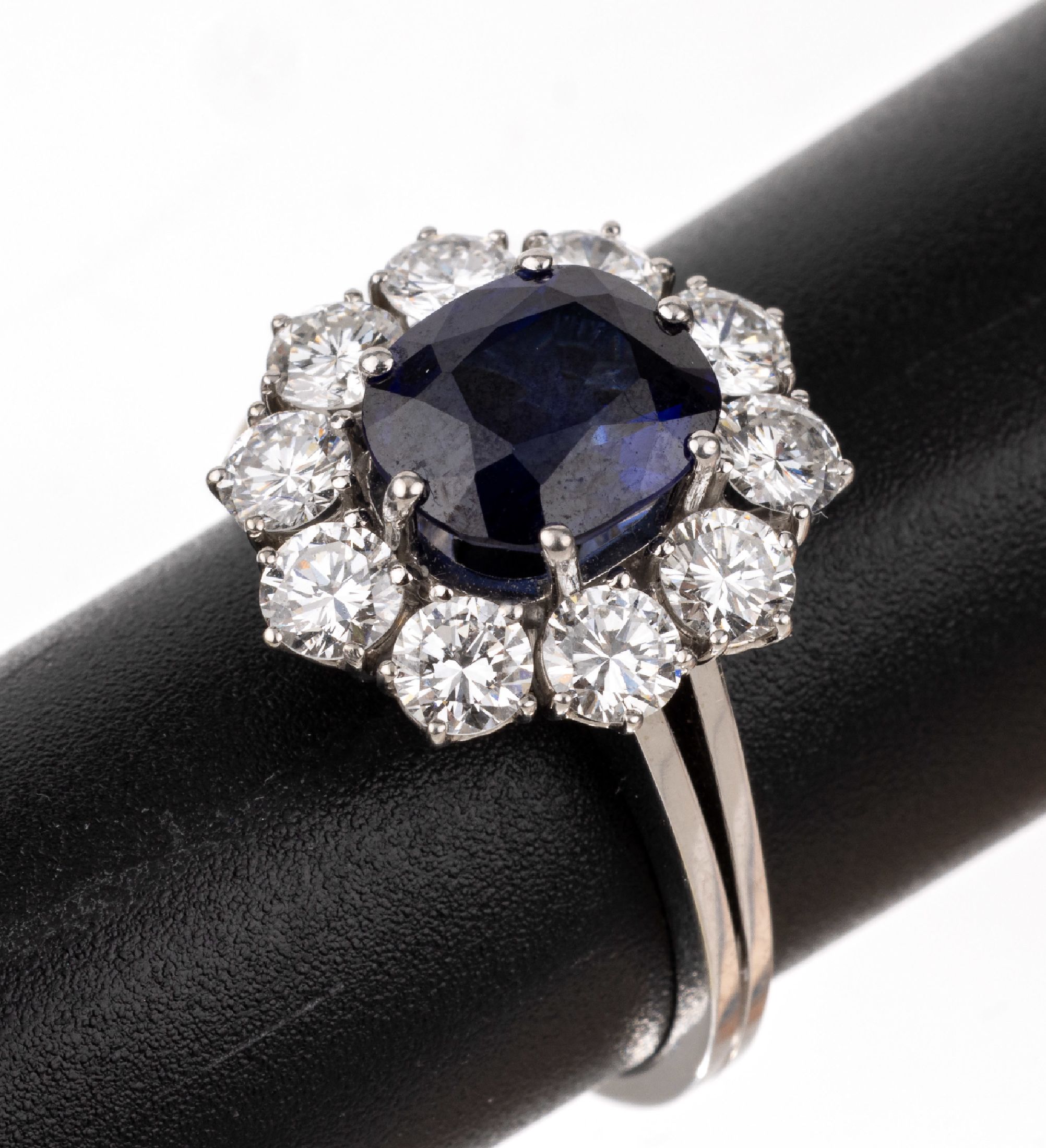 18 kt Gold Saphir-Brillant-Ring, WG 750/000, ovalfacett. Saphir ca. 2.60 ct, gute Farbe, 10 Brillanten zus. ca. 1.55 ct feines Weiß/vs, ca. 5.4 g, ...