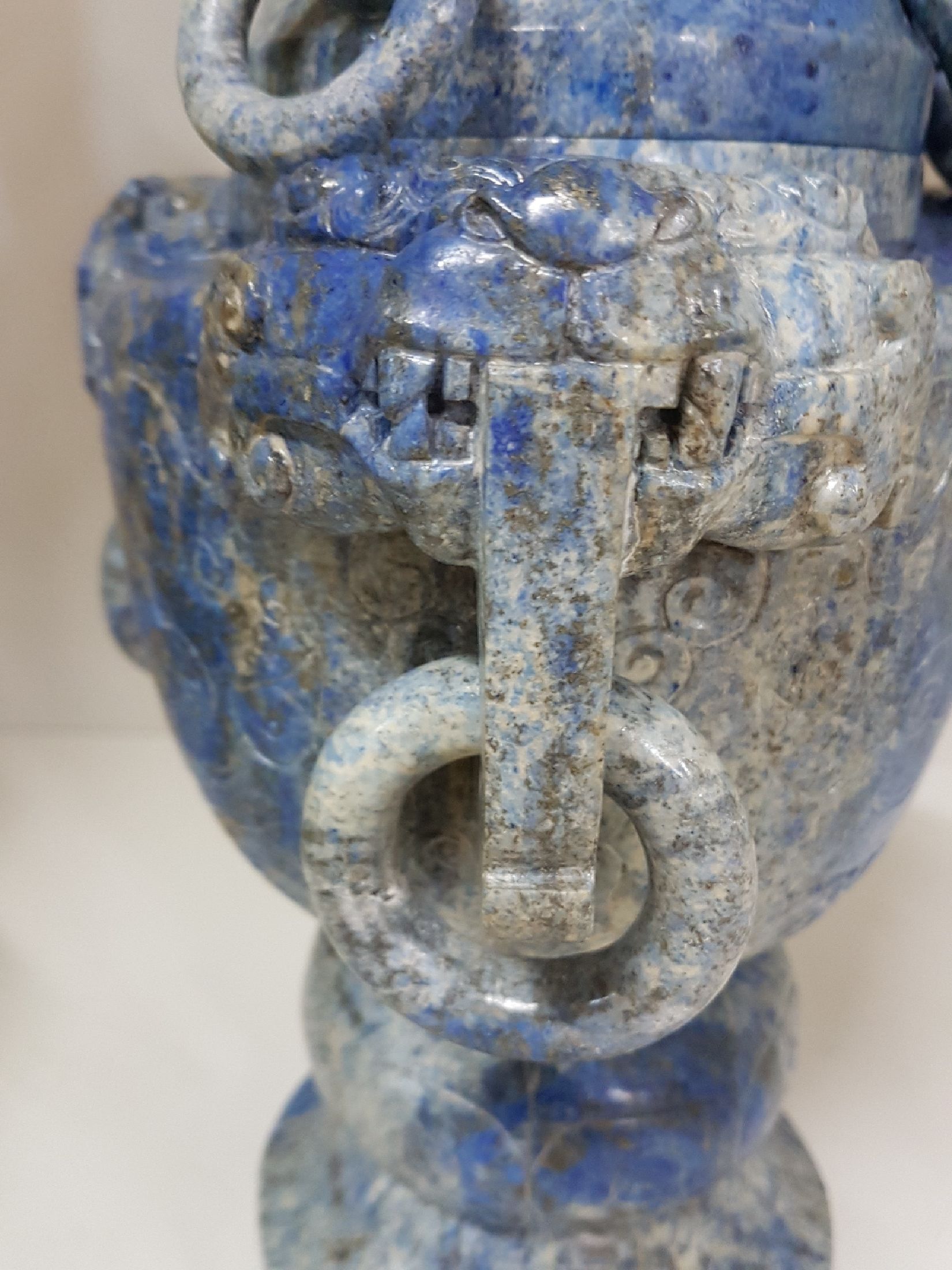 Detail d: Deckelvase aus Lapislazuli, China, 20. Jh., Doppelhenkel mit Ringen, beschnitzt mit stil. Masken, Fo-Löwen- Bekrönung, 34.5.5 x 20 cm