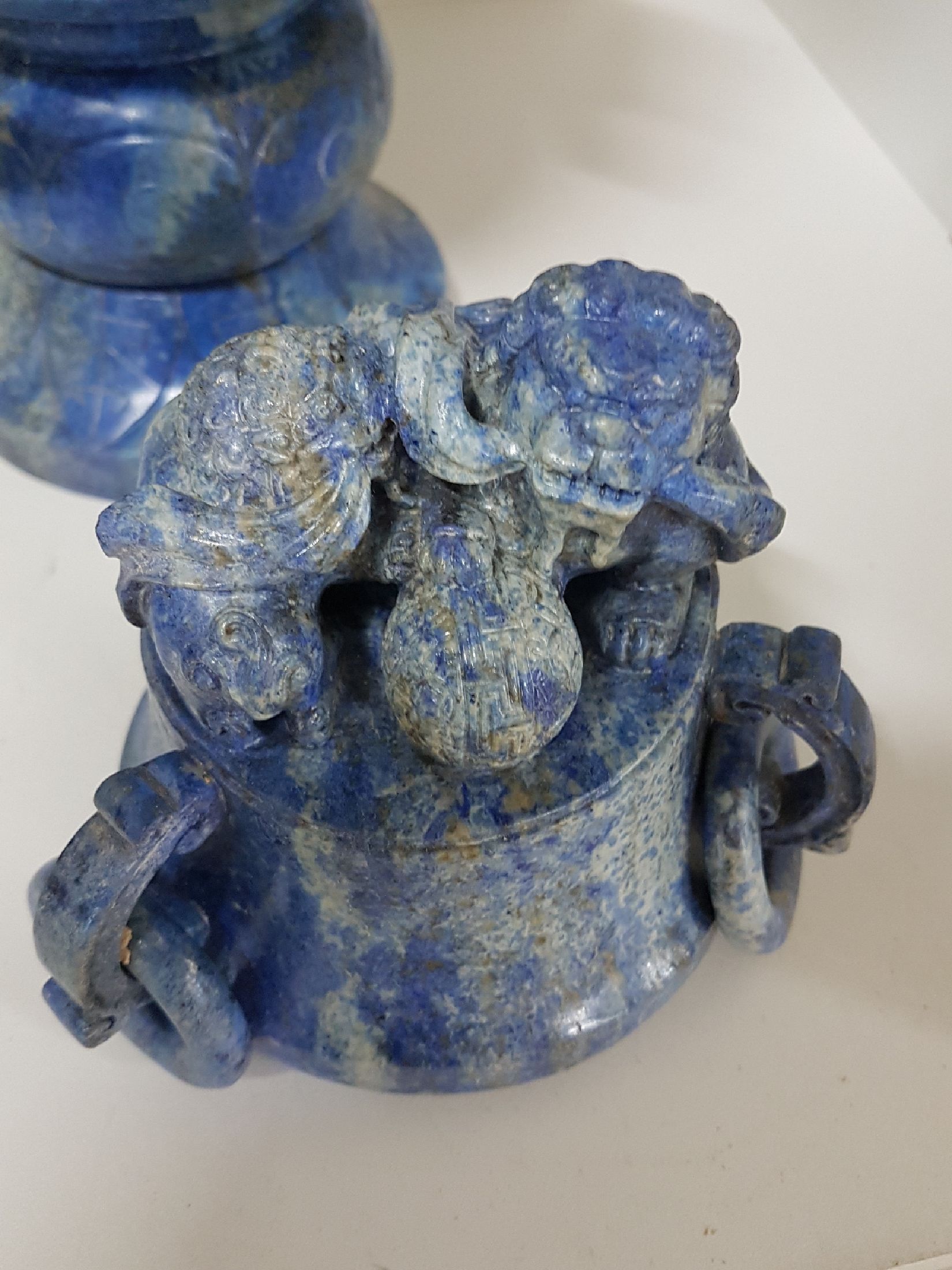 Detail i: Deckelvase aus Lapislazuli, China, 20. Jh., Doppelhenkel mit Ringen, beschnitzt mit stil. Masken, Fo-Löwen- Bekrönung, 34.5.5 x 20 cm