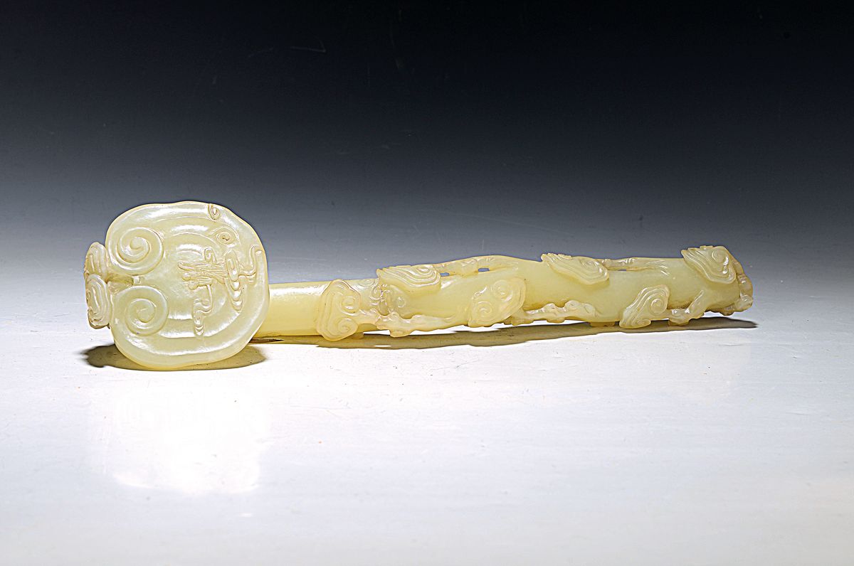 Große Ruyi-Zepter, China, Jade, leicht geschwungene Form, reich beschnitzt, z.T. vollplastisch, am Stil rest., H. ca. 39 cm