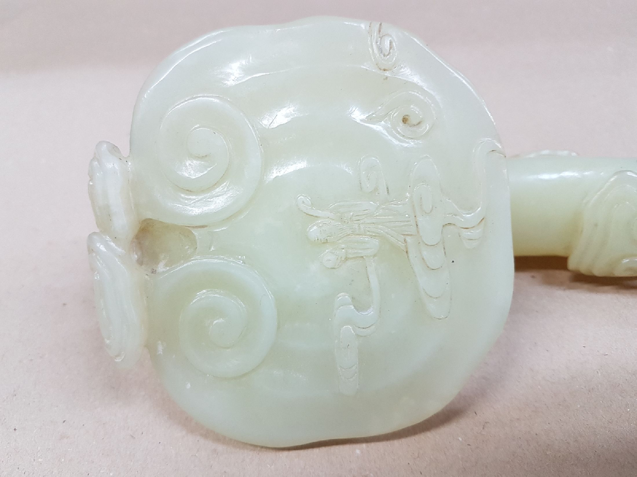 Detail c: Große Ruyi-Zepter, China, Jade, leicht geschwungene Form, reich beschnitzt, z.T. vollplastisch, am Stil rest., H. ca. 39 cm