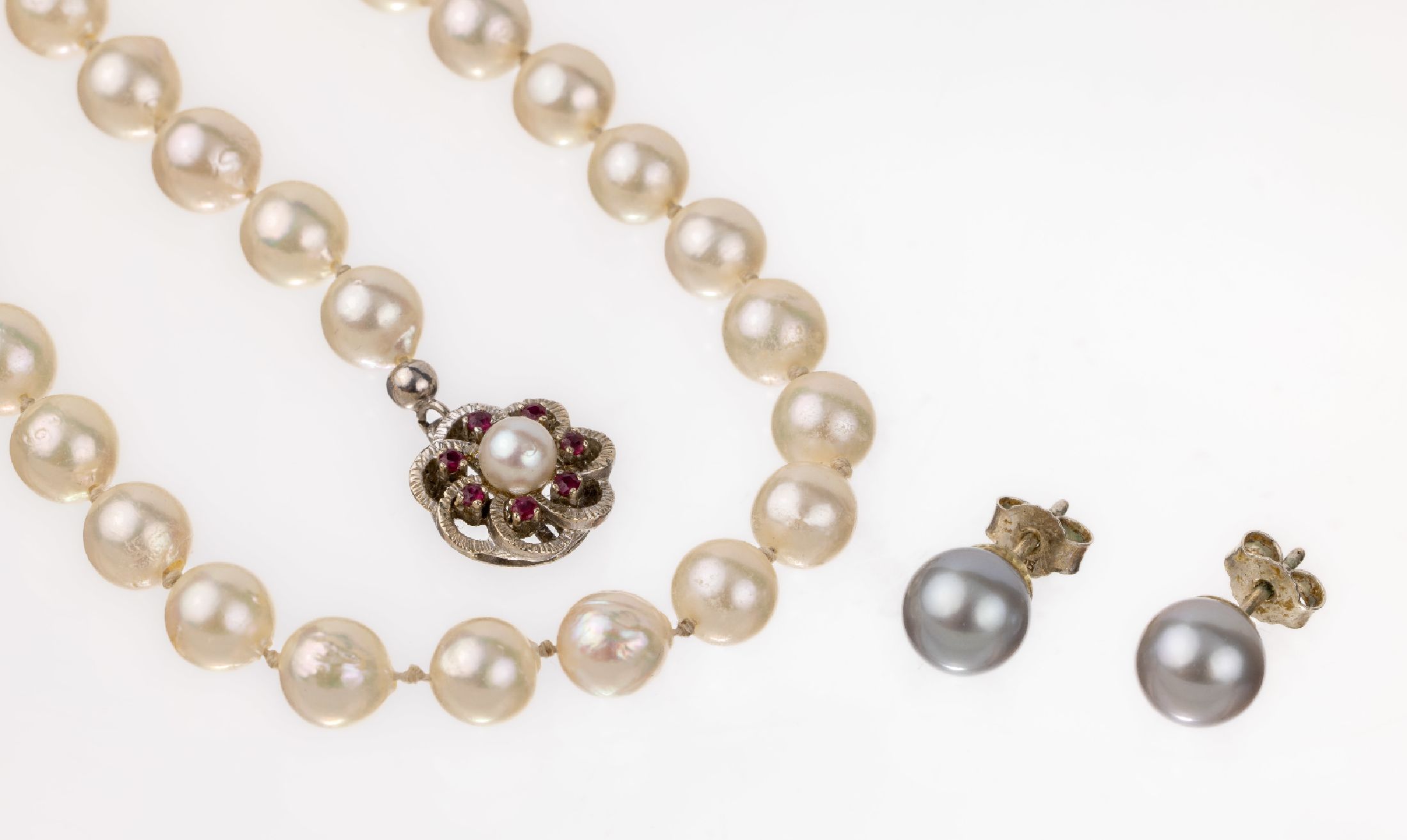 Zuchtperl-Collier mit 14 kt Gold Rubin -Schließe, WG 585/000, 54 l. unrunde Akoyazuchtperlen, D. ca. 7.3 mm, Steckschließemit kl. rundfacett. ...