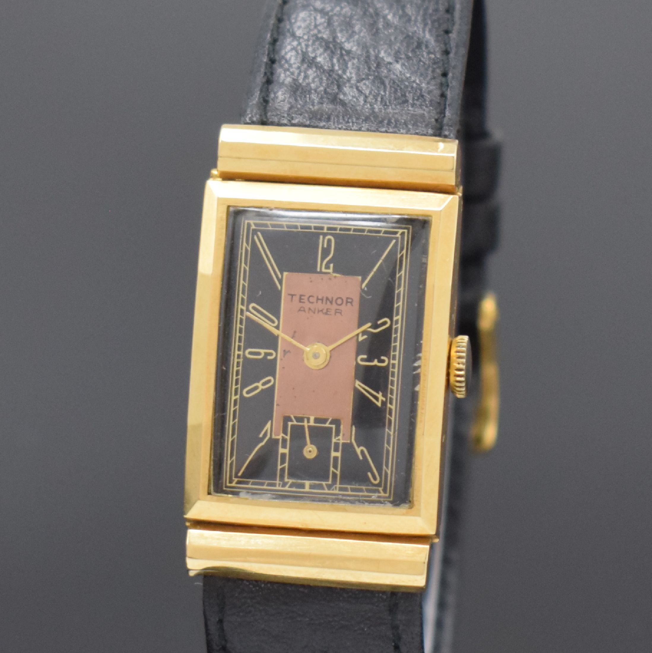 Detail a: TECHNOR rechteckige Armbanduhr in GG 750/000, Schweiz um 1935, Handaufzug, mediterranes Scharniergeh. m. facettierten Rollen-Anstößen, schwarzes ...