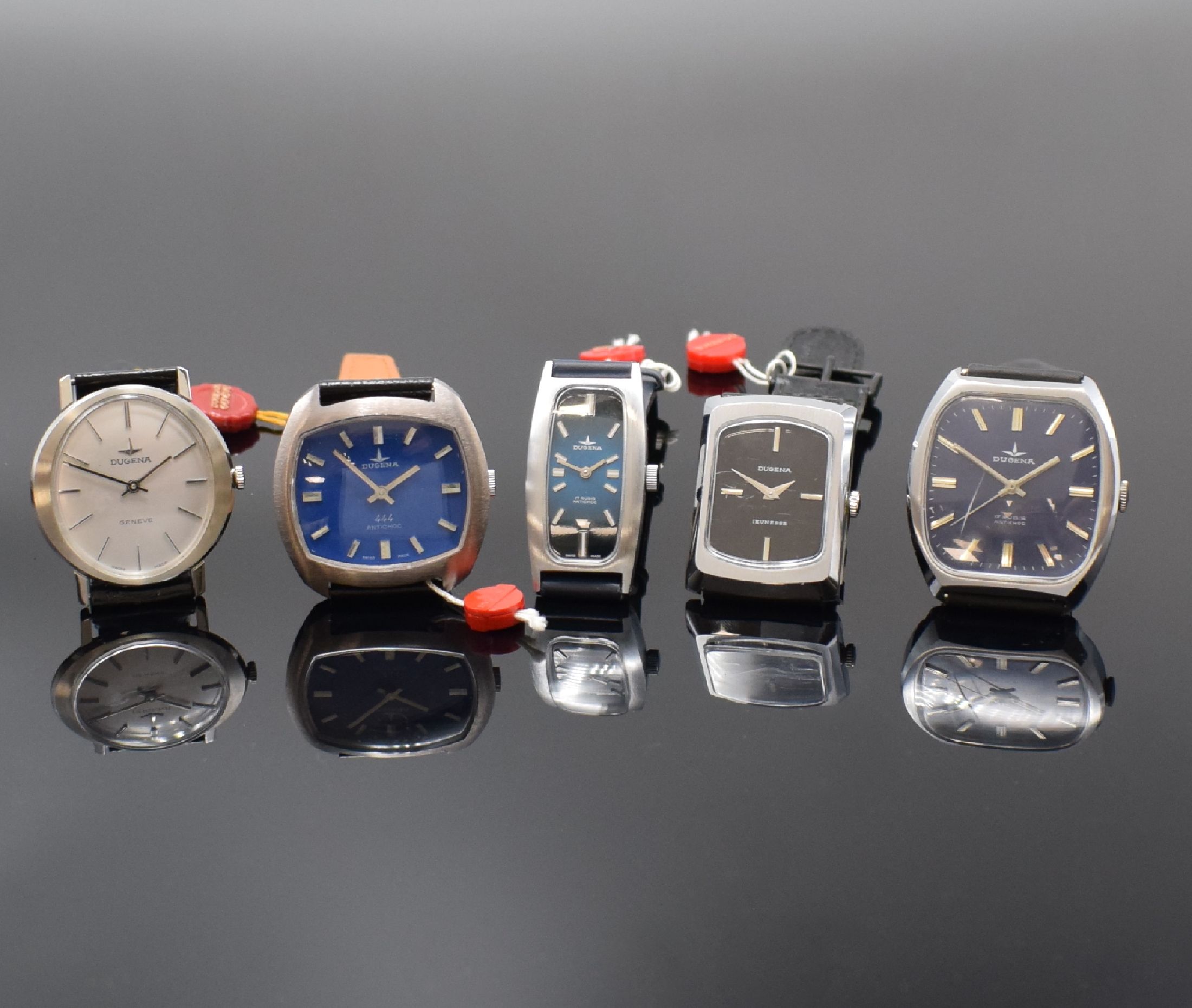 DUGENA 5 Armbanduhren aus Lagerbestand, Schweiz um 1970, Handaufzug, 4 verchromte u. 1 Stahlgeh. m. aufgedr. Stahlboden, Gläser teilw. besch., ...
