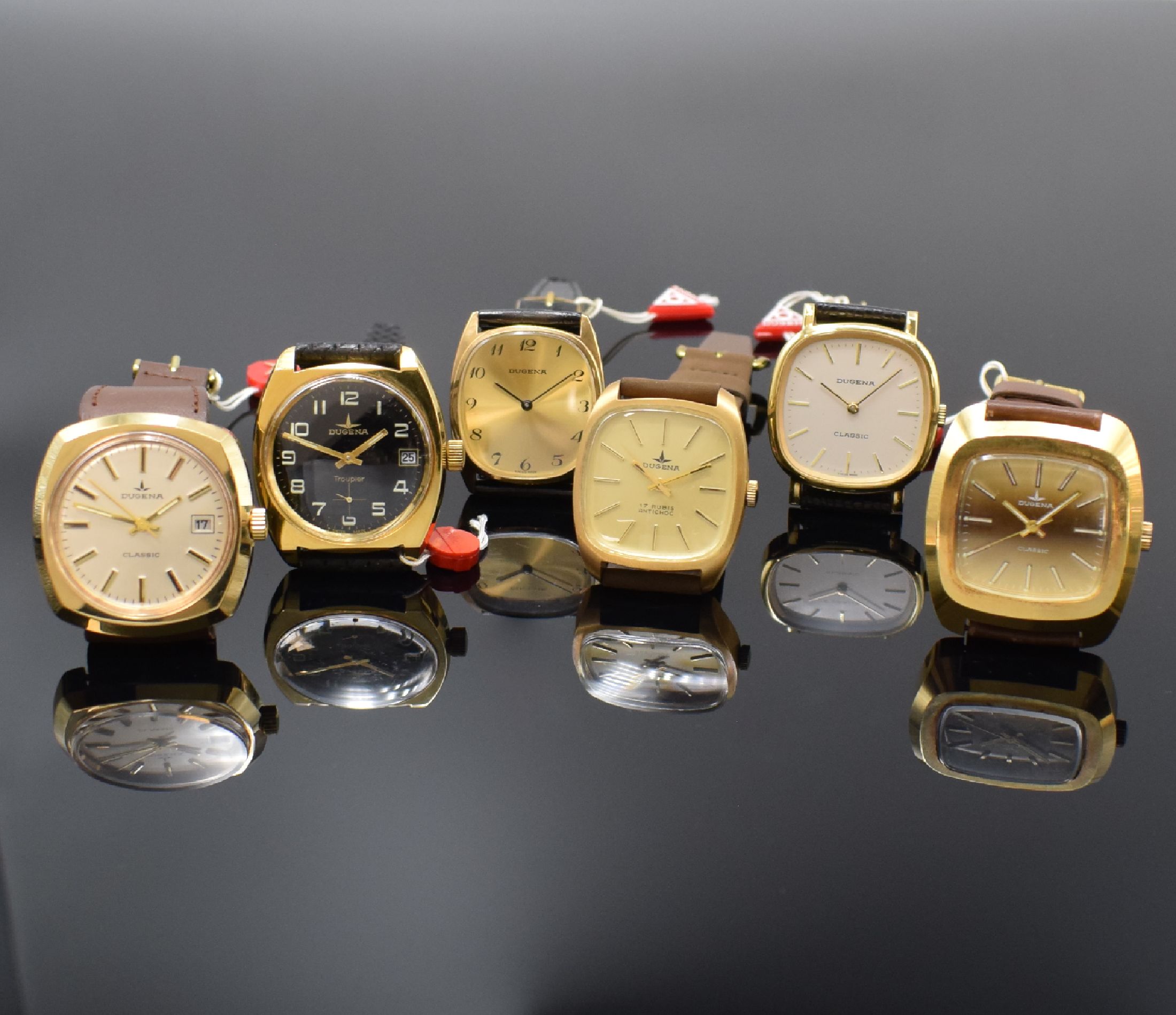 DUGENA 6 vergoldete Armbanduhren aus Lagerbestand, Schweiz um 1970, Handaufzug, 2-tlg. Geh. m. Stahlboden, 4 x aufgedr., 2 x verschr., verschiedene ...