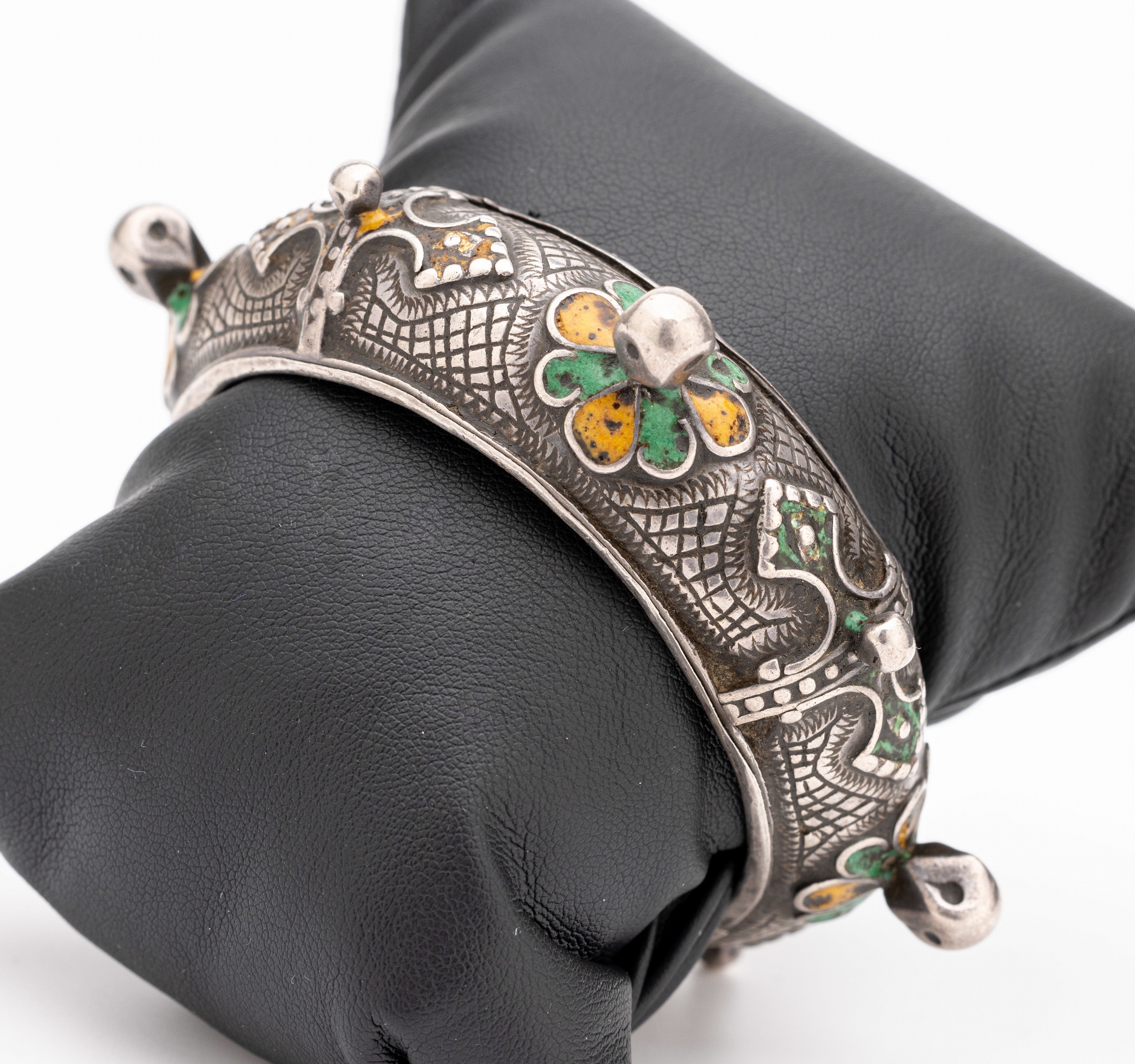 Armreif mit Email, Silber gepr., wohl Marokko um 1900, oberfl. grav., Email in Grün und Gelb, D. ca. 5.9 cm, altersbed. Gebr. -Spuren