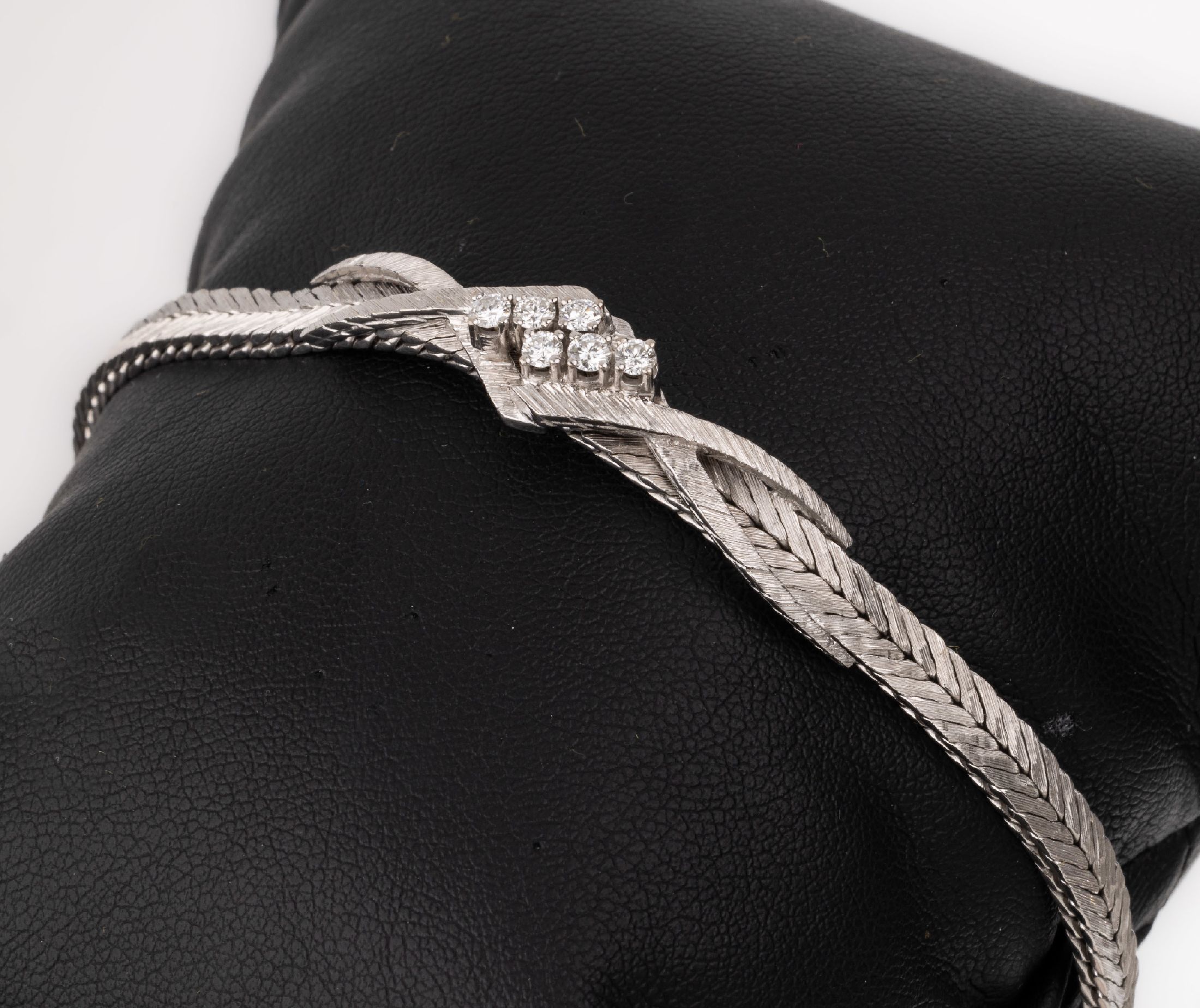 18 kt Gold Brillant-Armband, WG 750/000, versteiftes Mittelteil mit 6 Brillanten zus. ca. 0.28 ct Weiß/si, L. ca. 17 cm, Kastenschloss mit ...