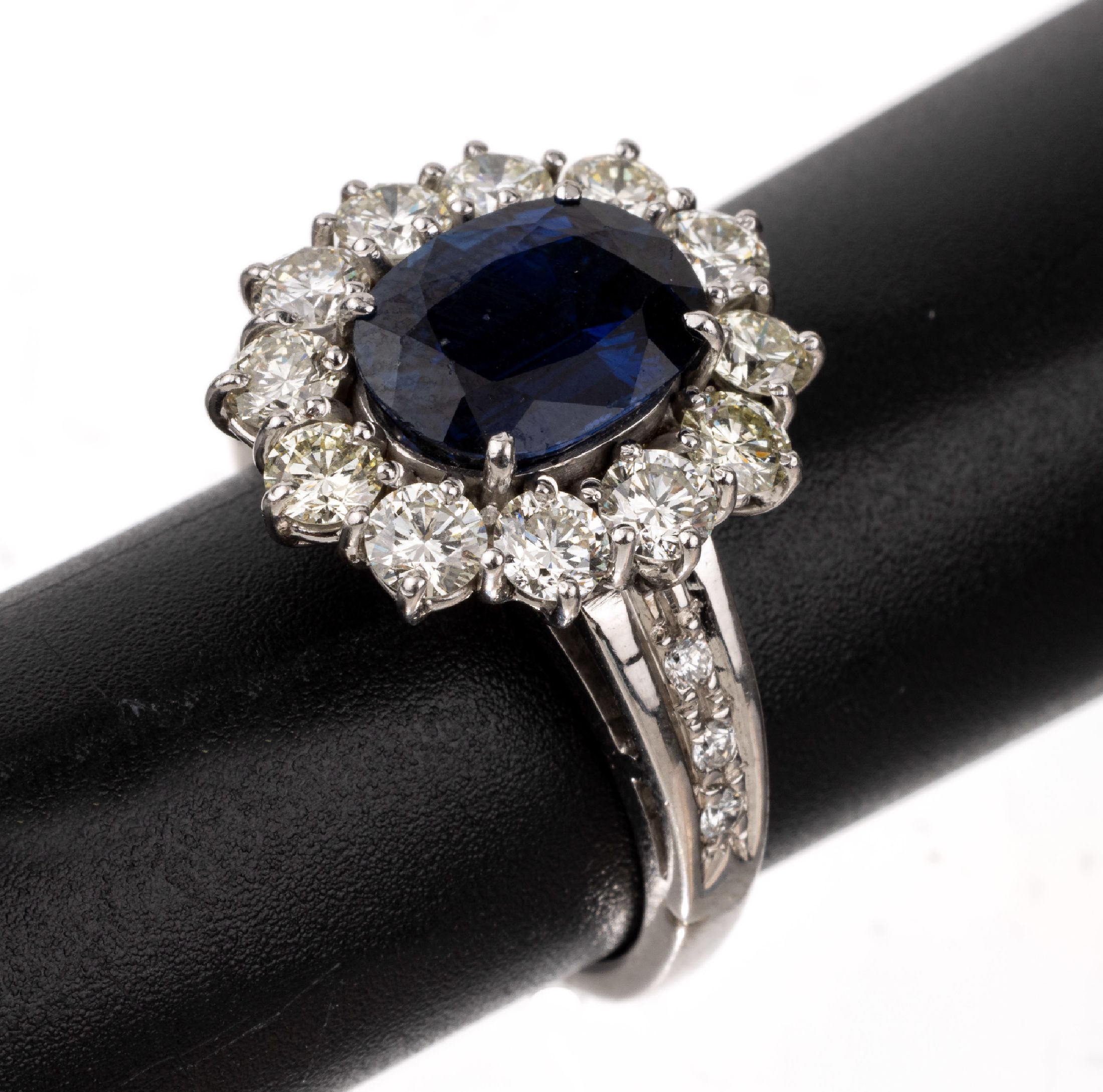 18 kt Gold Saphir-Brillant-Ring, WG 750/000, mittig ovalfacett. Saphir ca. 4.0 ct,umgeben von 18 Brillanten zus. ca. 1.50 ct l.get.Weiß-Weiß/si, ...