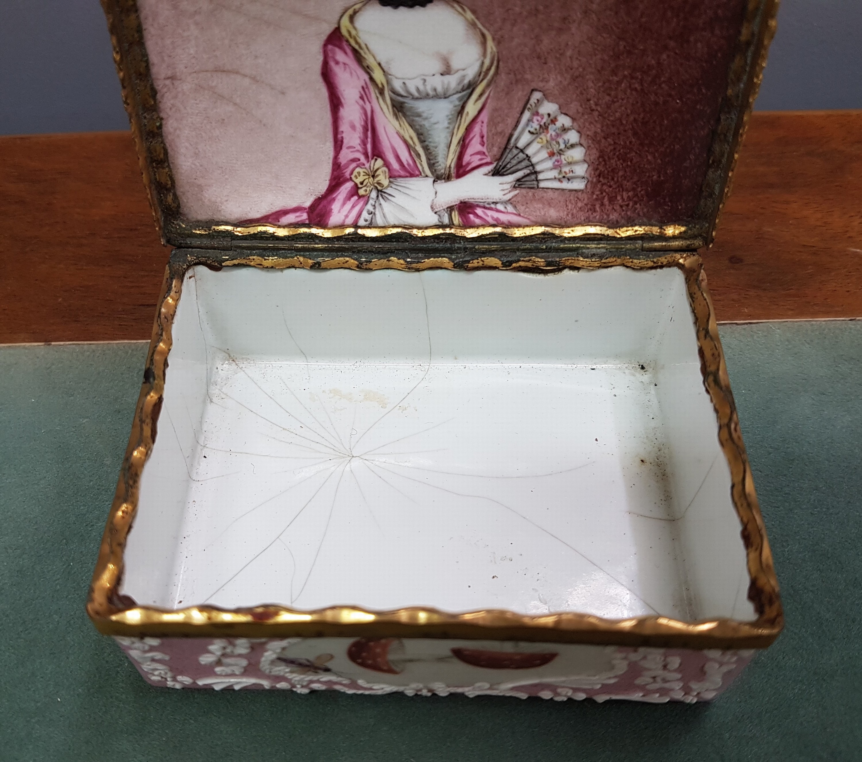 Detail e: Deckeldose, Frankreich, 19. Jh., Metall fein emailliert in rosa mit weißen aufgelegten Ornamenten, in Kartuschen Emailmalerei von Apfel, Pilzen, ...