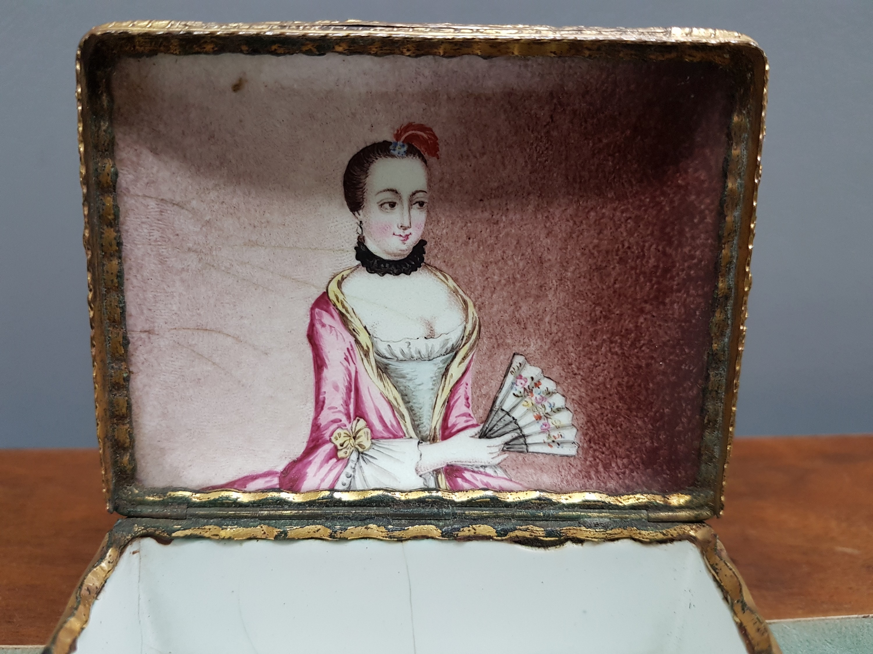 Detail f: Deckeldose, Frankreich, 19. Jh., Metall fein emailliert in rosa mit weißen aufgelegten Ornamenten, in Kartuschen Emailmalerei von Apfel, Pilzen, ...