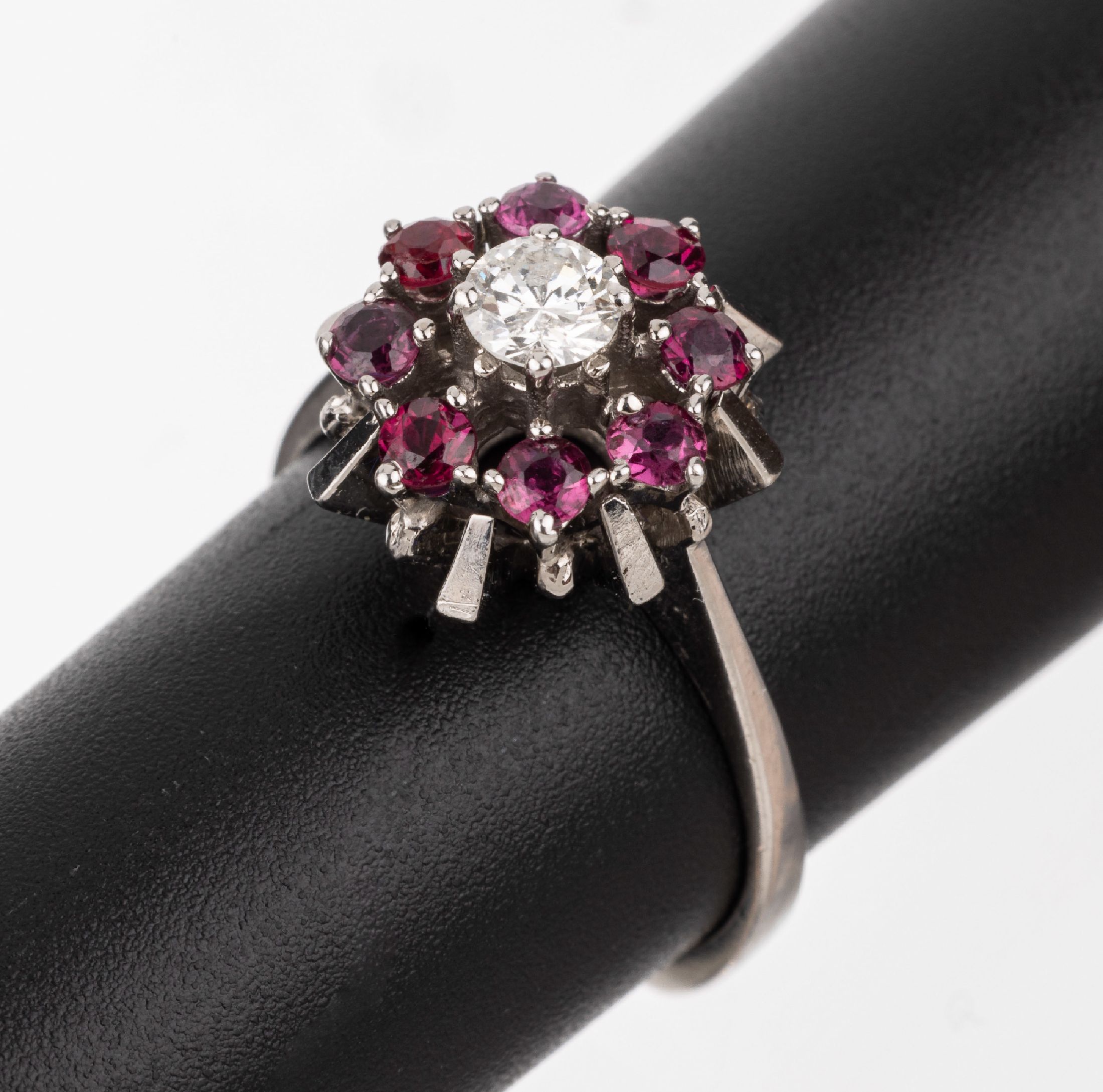 14 kt Gold Brillant-Rubin-Ring, WG 585/000,mittig erhaben gefasster Brillant ca. 0.25 ct Weiß/p, umgeben von 8 rundfacett. Rubinen zus. ca. 0.25 ...
