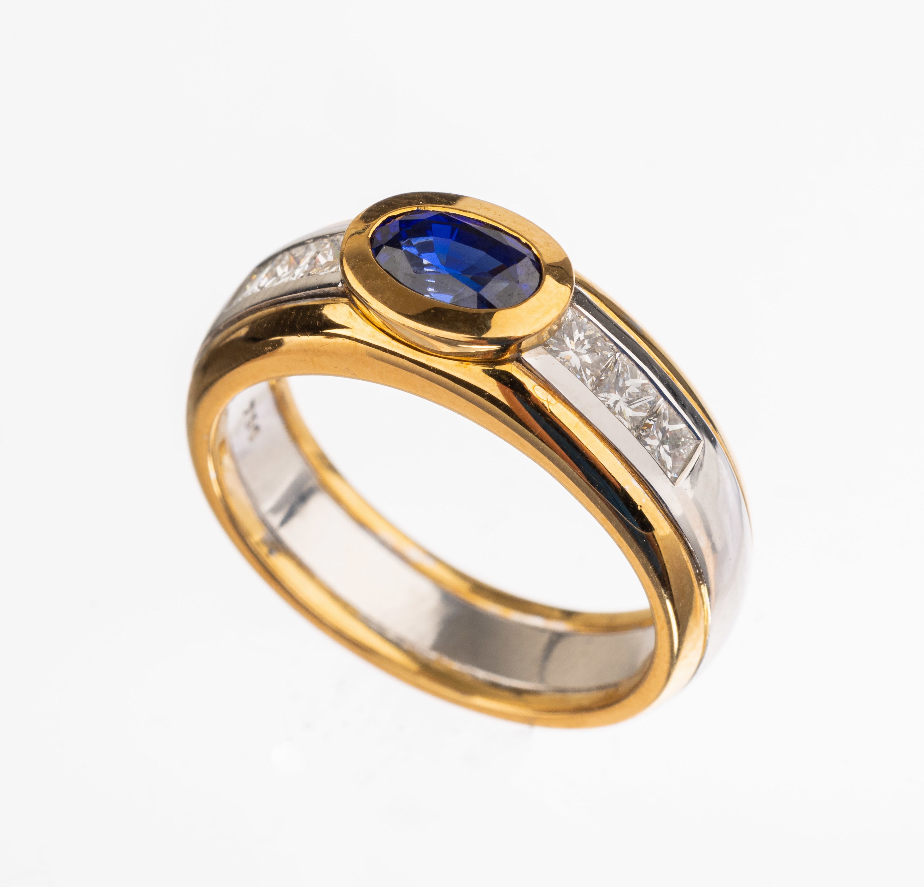 18 kt Gold Saphir-Diamant-Ring, GG/WG 750/000, mittig ovalfacett. Saphir von sehr schöner Farbe ca. 1.06 ct, 6 Princesscut Diamanten zus. ca. 0.51 ...