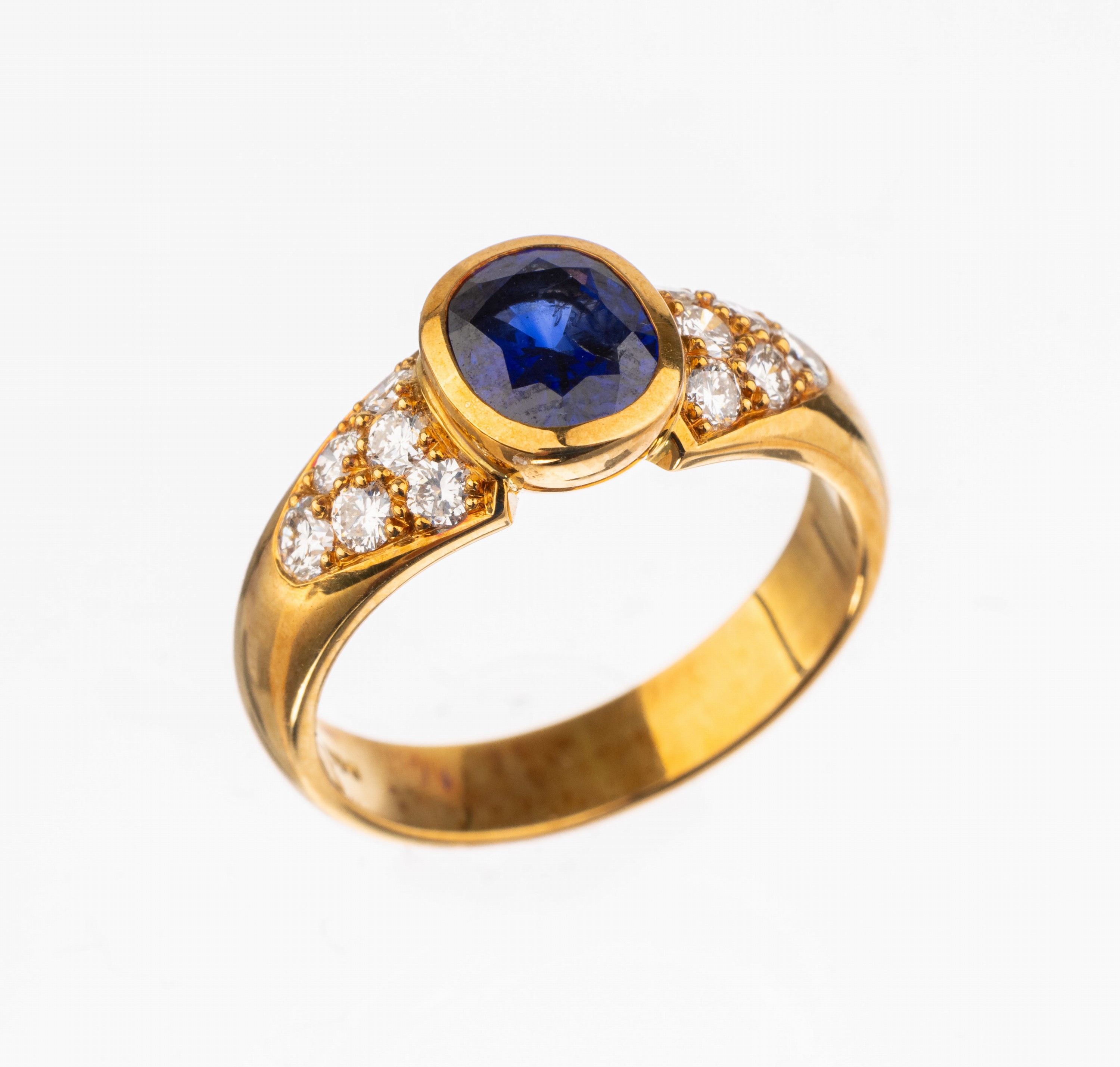 18 kt Gold Saphir-Brillant-Ring, GG 750/000, mittig ovalfacett. Saphir von sehr schöner Farbe ca. 1.30 ct, 12 Brillanten zus. ca. 0.49 ct feines ...