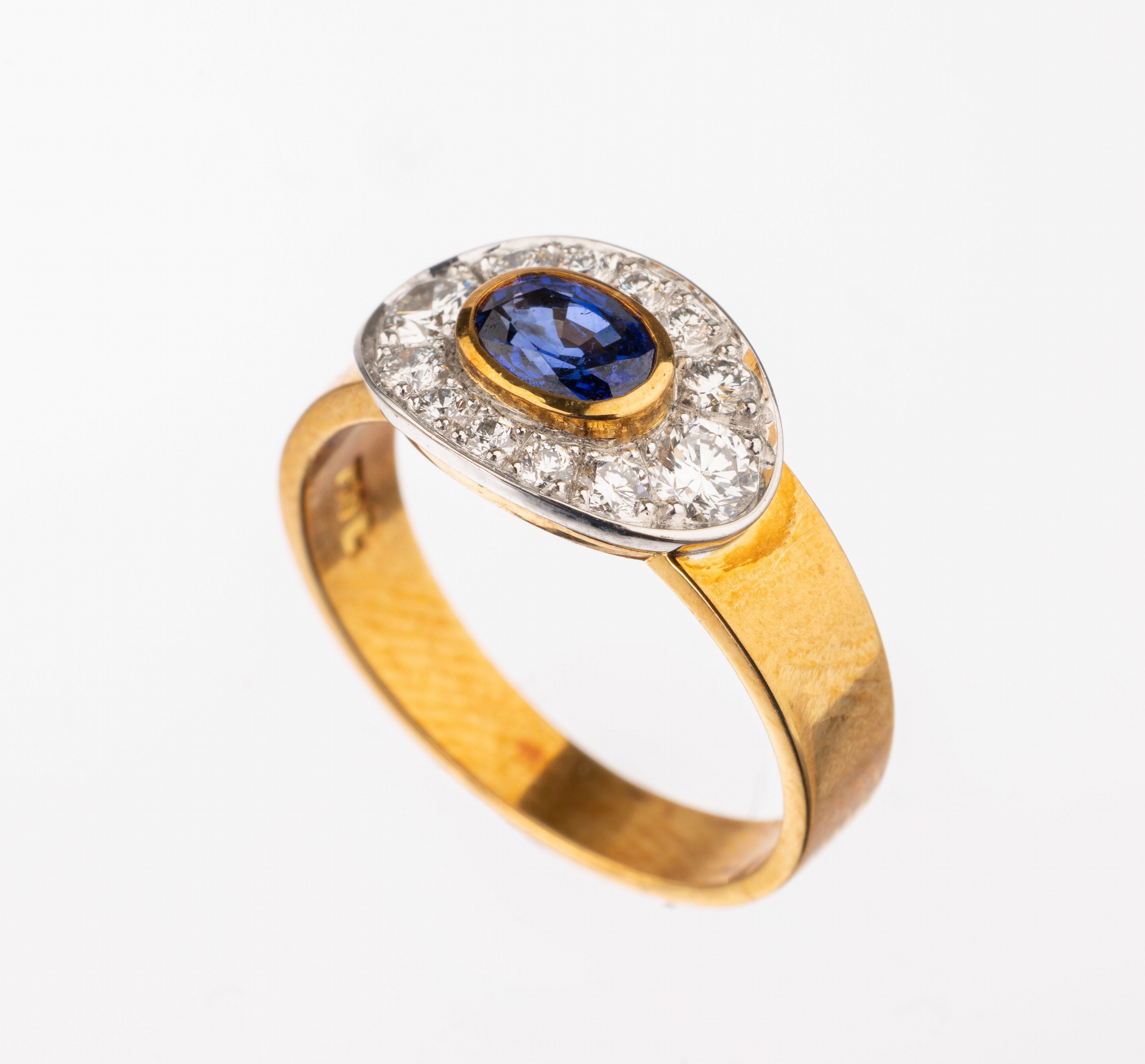 18 kt Gold Saphir-Brillant-Ring, GG/WG 750/000, Ringkopf oval in WG, mittig ovalfacett. Saphir ca. 0.57 ct umgeben von 12 Brillanten zus. ca. 0.47 ...