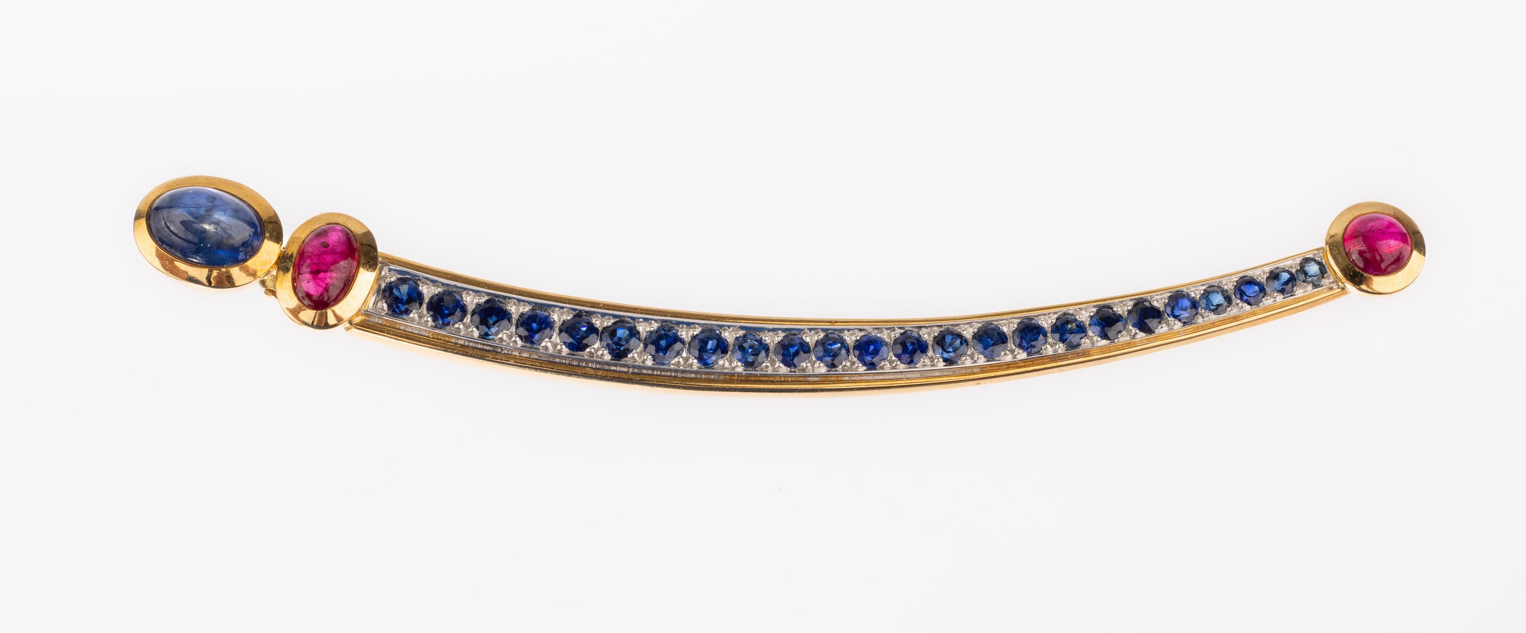 18 kt Gold Saphir-Rubin-Brosche, GG/WG 750/000, geschwungen, 1 Saphir-Cabochon ca. 2.05 ct, 24 rundfacett. Saphire zus. ca. 2.13 ct, 2 ...