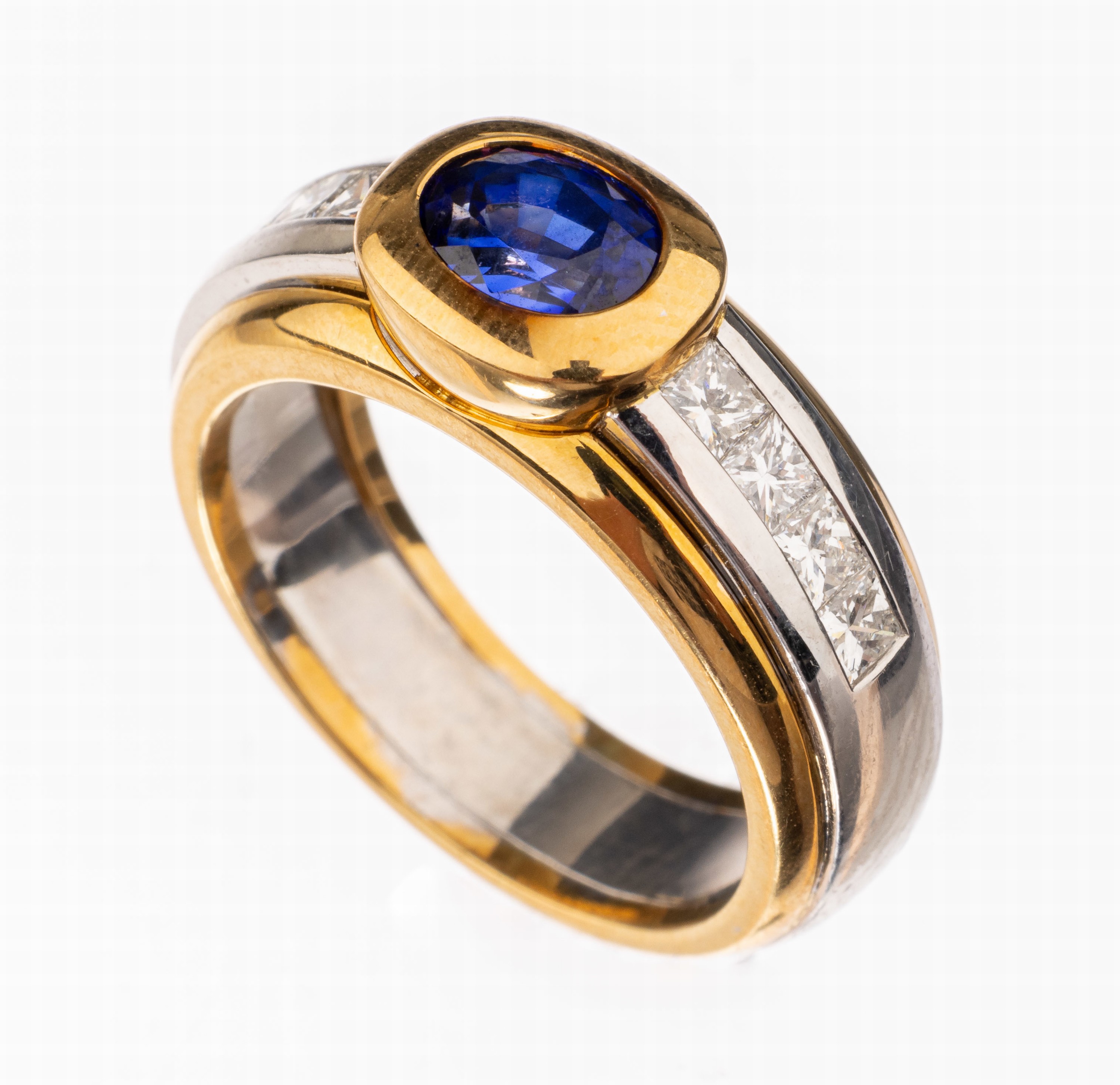 18 kt Gold Saphir-Diamant-Ring, GG/WG 750/000, mittig ovalfacett. Saphir von sehr schöner Farbe ca. 1.32 ct, 8 Princesscut Diamanten zus. ca. 0.96 ...