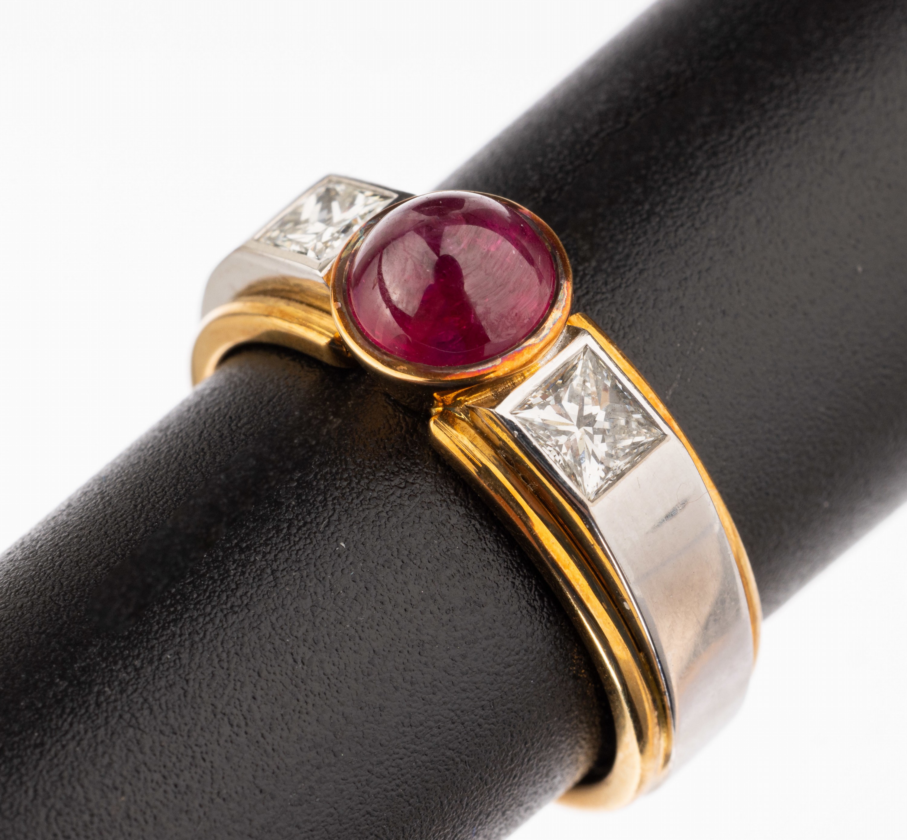 18 kt Gold Rubin-Diamant-Ring, GG/WG 750/000, mittig runder Rubincabochon von intensiver Farbe ca. 1.78 ct, seitl. 2 Princesscut Diamanten zus. ca. ...