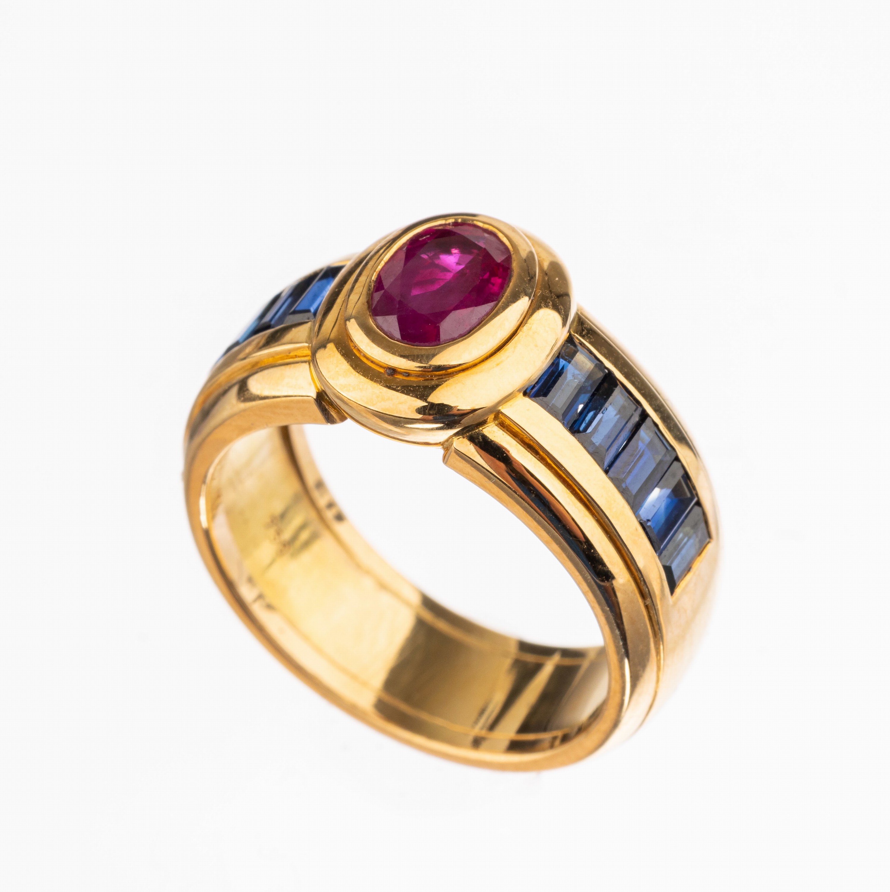 18 kt Gold Rubin-Saphir-Ring, GG 750/000, mittig ovalfacett. Rubin von intensiver Farbe ca. 0.91 ct, seitl. 10 Saphir-Baguettes zus. ca. 1.68 ct, ...
