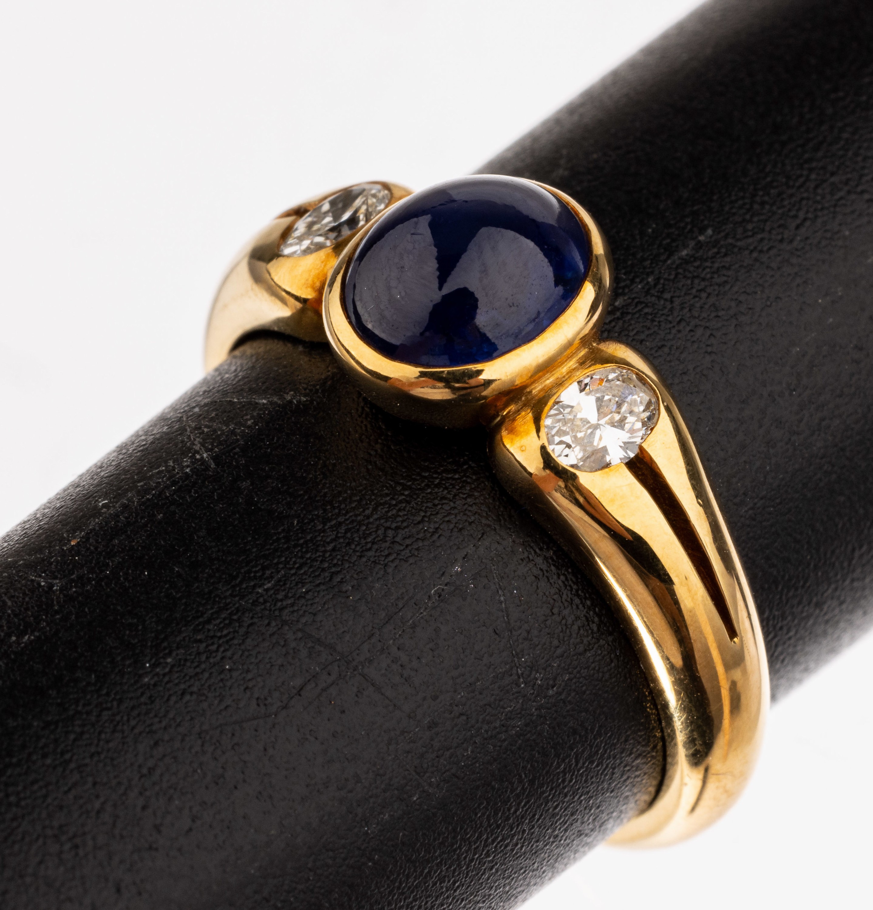 18 kt Gold Saphir-Brillant-Ring, GG 750/000, mittig ovaler Saphir-Cabochon ca. 1.66 ct, seitl. 2 ovalfacett. Diamanten zus. ca. 0.24 ct Weiß/vs, RW ...
