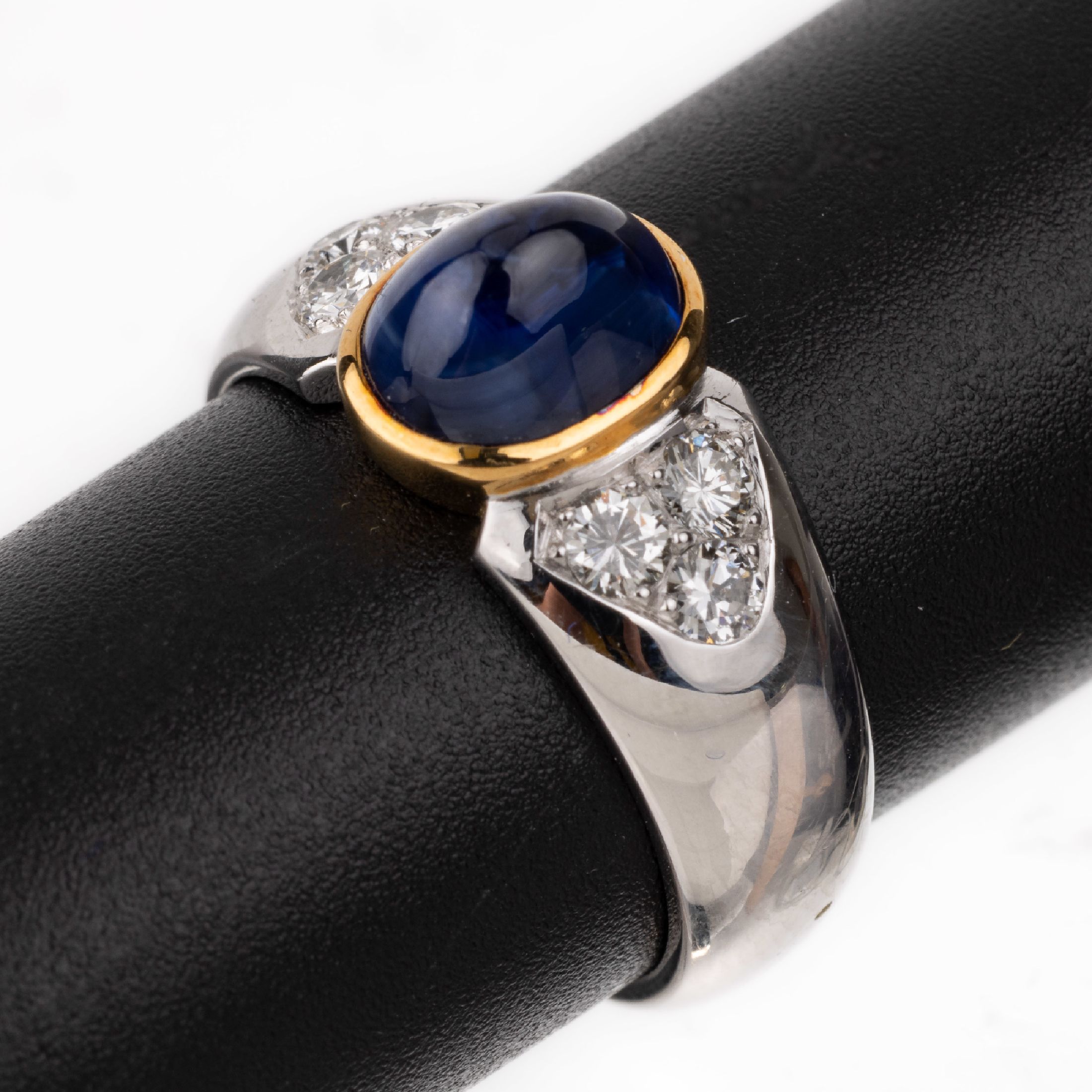 18 kt Gold Saphir-Brillant-Ring, WG/GG 750/000, mittig ovaler in GG gefasster Saphir-Cabochon ca. 2.71 ct, 6 Brillanten zus. ca. 0.43 ct ...