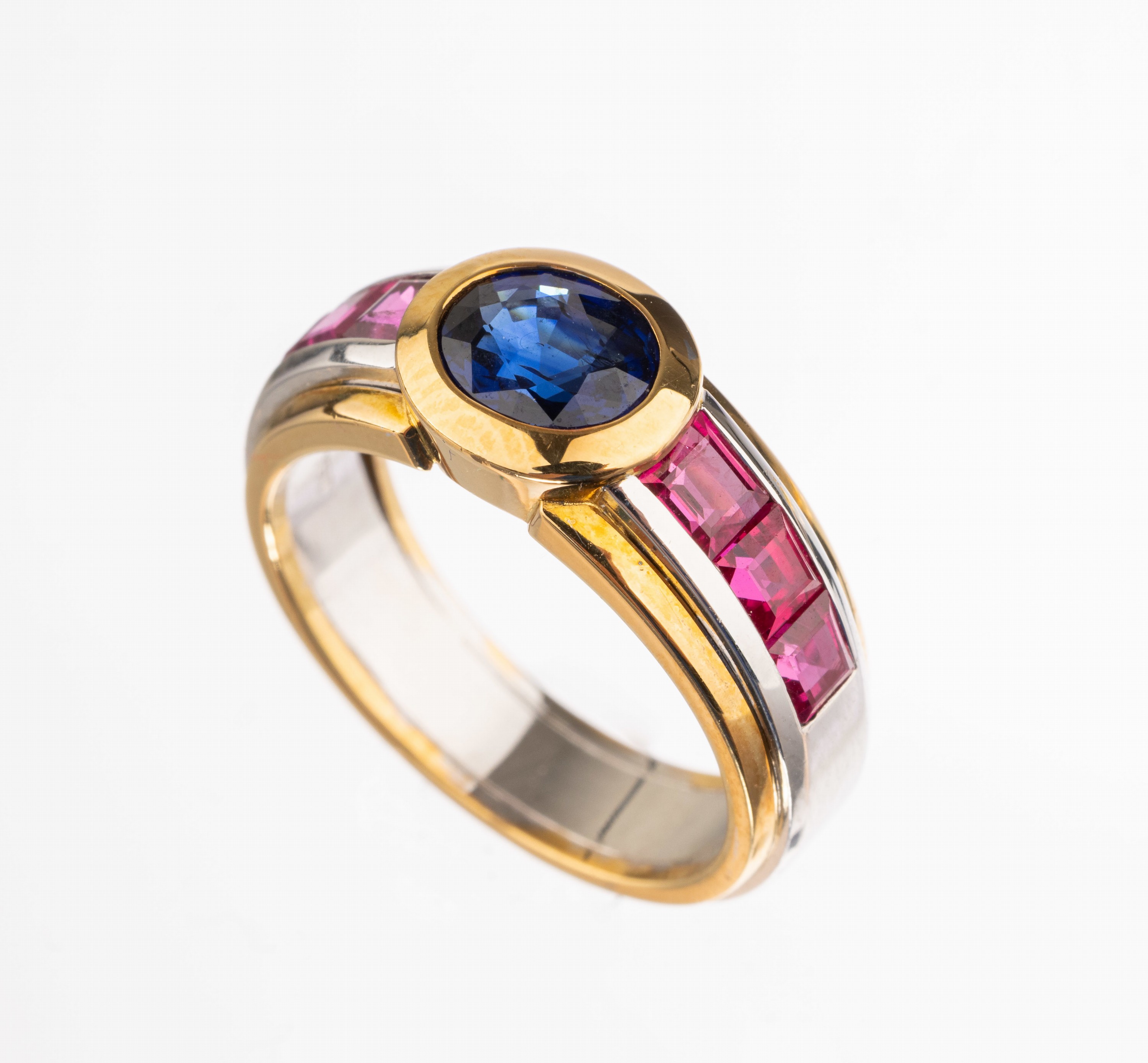 18 kt Gold Farbstein-Ring, GG/WG 750/000, ovalfacett. Saphir ca. 1.27 ct, 6 Rubin- Carrees zus. ca. 1.66 ct, Farbstein von intensiver Farbe, ca. 9.1 ...
