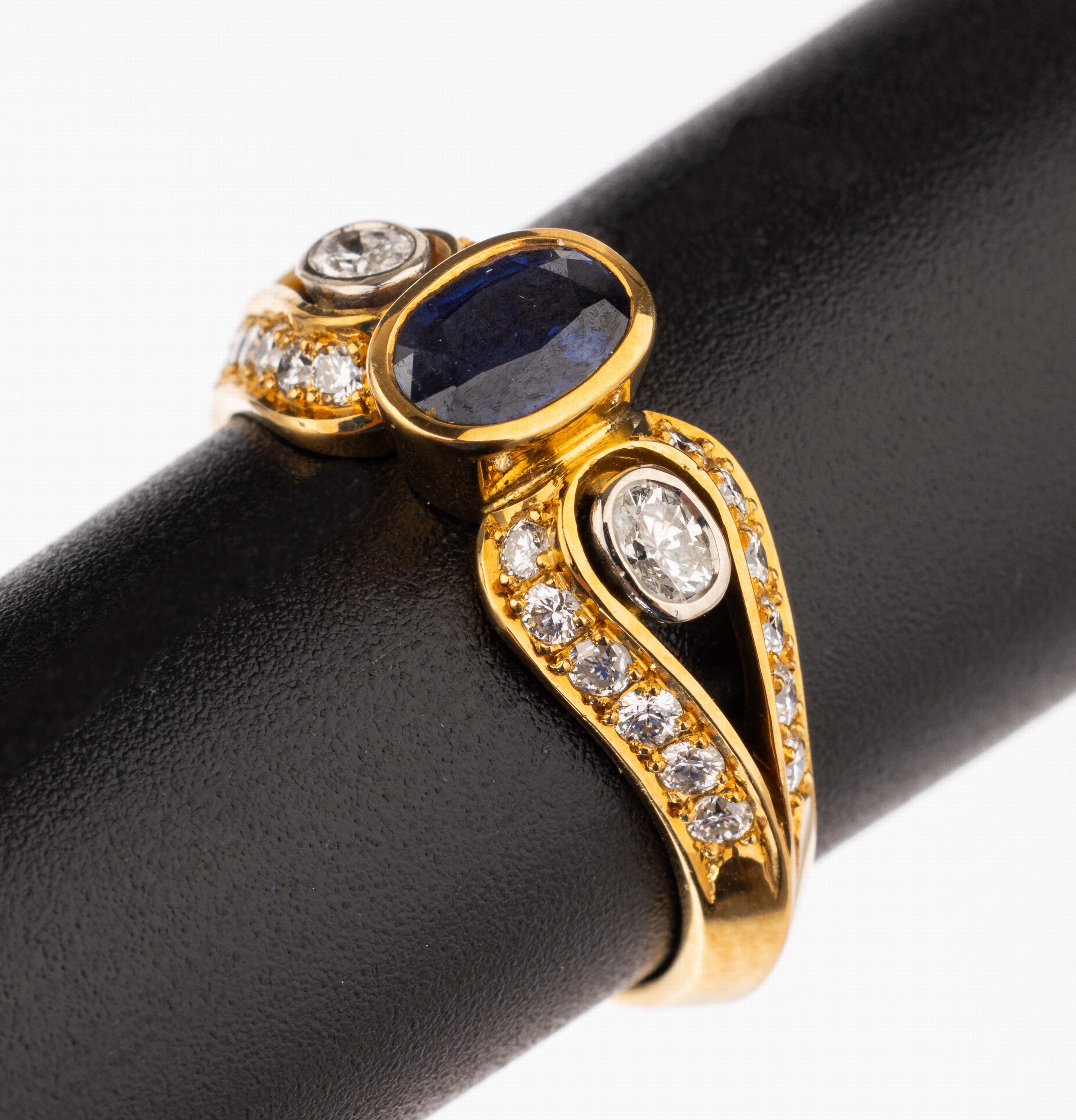 18 kt Gold Saphir-Diamant-Ring, GG 750/000,mittig ovalfacett. Saphir ca. 0.72 ct, 24 Brillanten und 2 ovalfacett. Diamanten zus. ca. 0.59 ct feines ...
