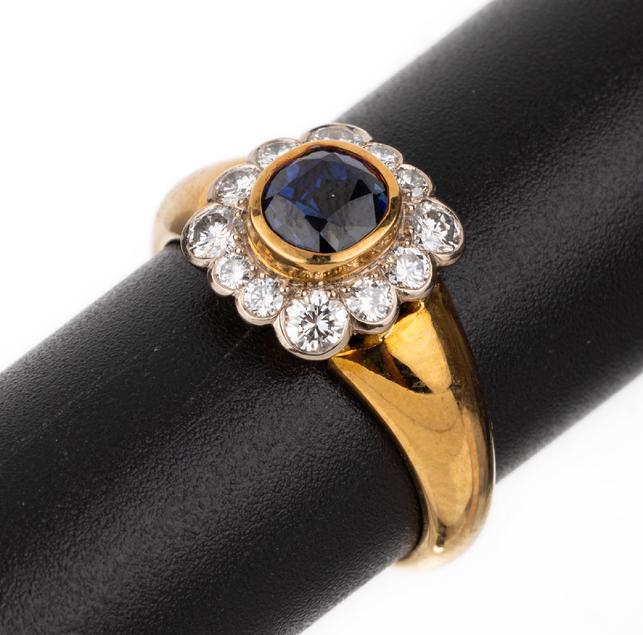 18 kt Gold Saphir-Brillant-Ring, GG 750/000, ovalfacett. Saphir von feiner Farbe ca. 1.27 ct, umrahmt von in WG gefassten Brillanten zus. ca. 0.52 ...