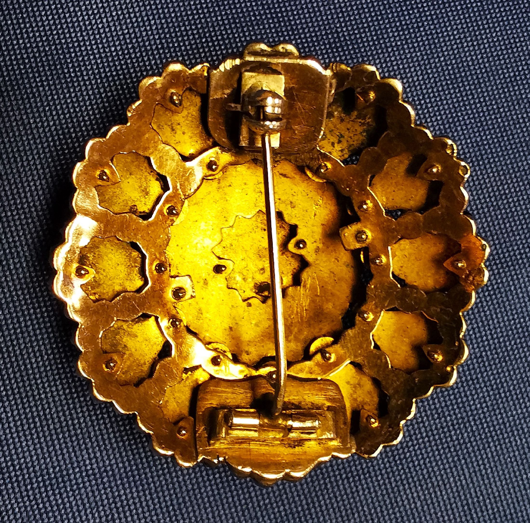 Detail b: Granat-Brosche, um 1880-90, Metall verg., Aufbau in mehreren Ebenen, facett. Granate, D. ca. 4.5 cm, Broschierung sek.