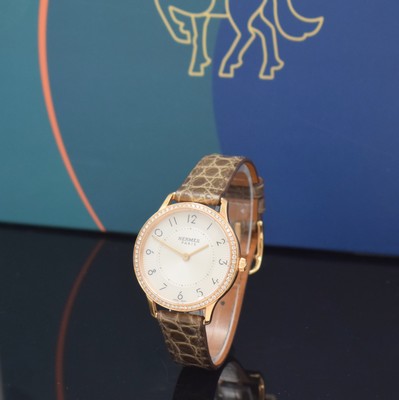 Image HERMES wristwatch series Slim d´Hermes reference CA2.271, 18k pink gold including original leather strap with original 18k pink gold buckle, bezel lavish diamonds set, quartz, case back screwed-down 4-times, silvered, engine-turned dial with Arabic hours, display of hours & minutes, diameter approx. 32 mm, Hermes storage back enclosed, unworn stock, condition 1-2