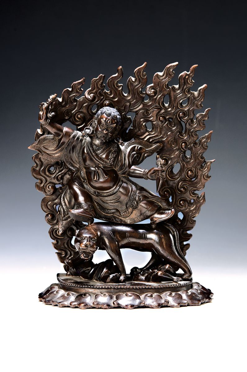Bronzeskulptur eines der acht Dharmapalas, Tibet/Nepal, 20.Jh., Bronze patiniert, Schutzgottheit auf einem Leoparden reitend, zuFüßen zwei ...