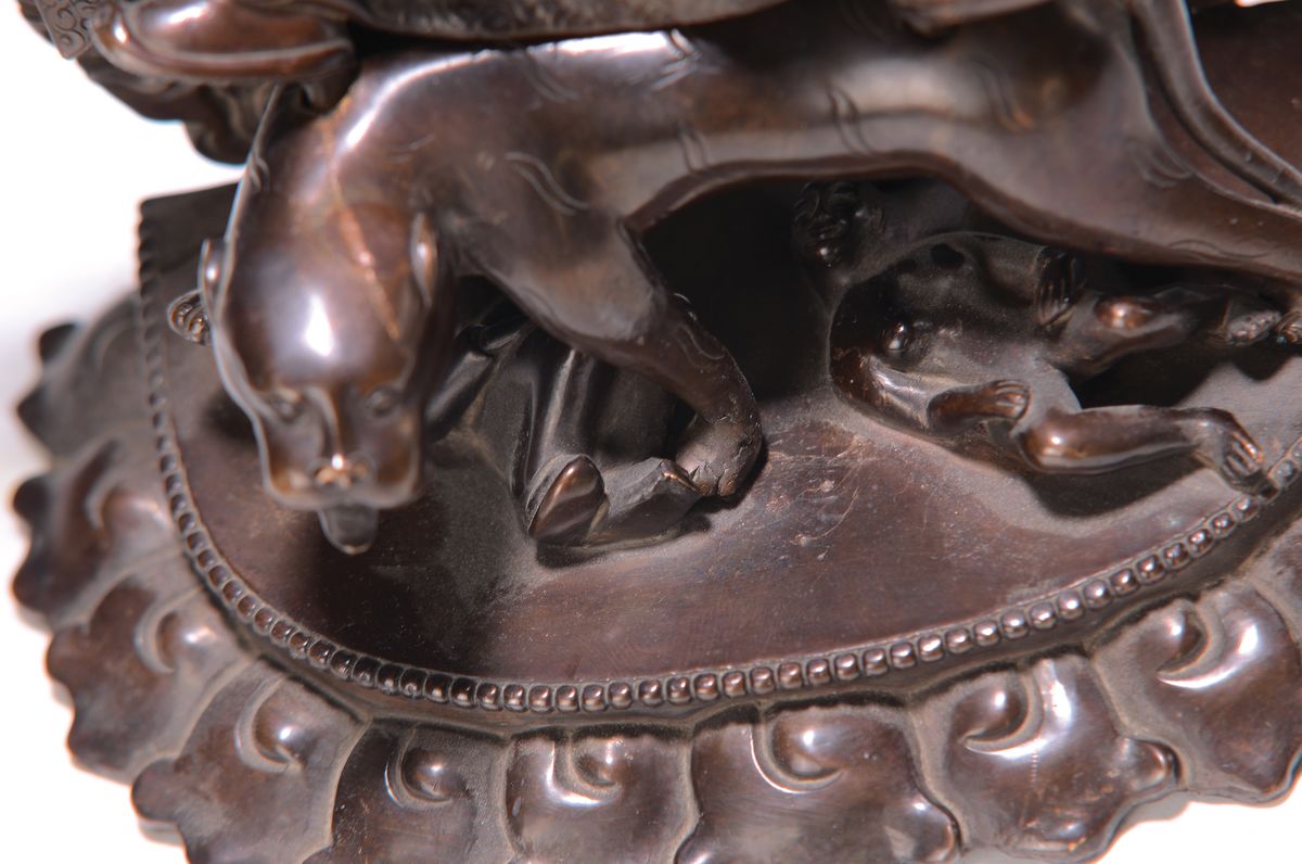Detail a: Bronzeskulptur eines der acht Dharmapalas, Tibet/Nepal, 20.Jh., Bronze patiniert, Schutzgottheit auf einem Leoparden reitend, zuFüßen zwei ...