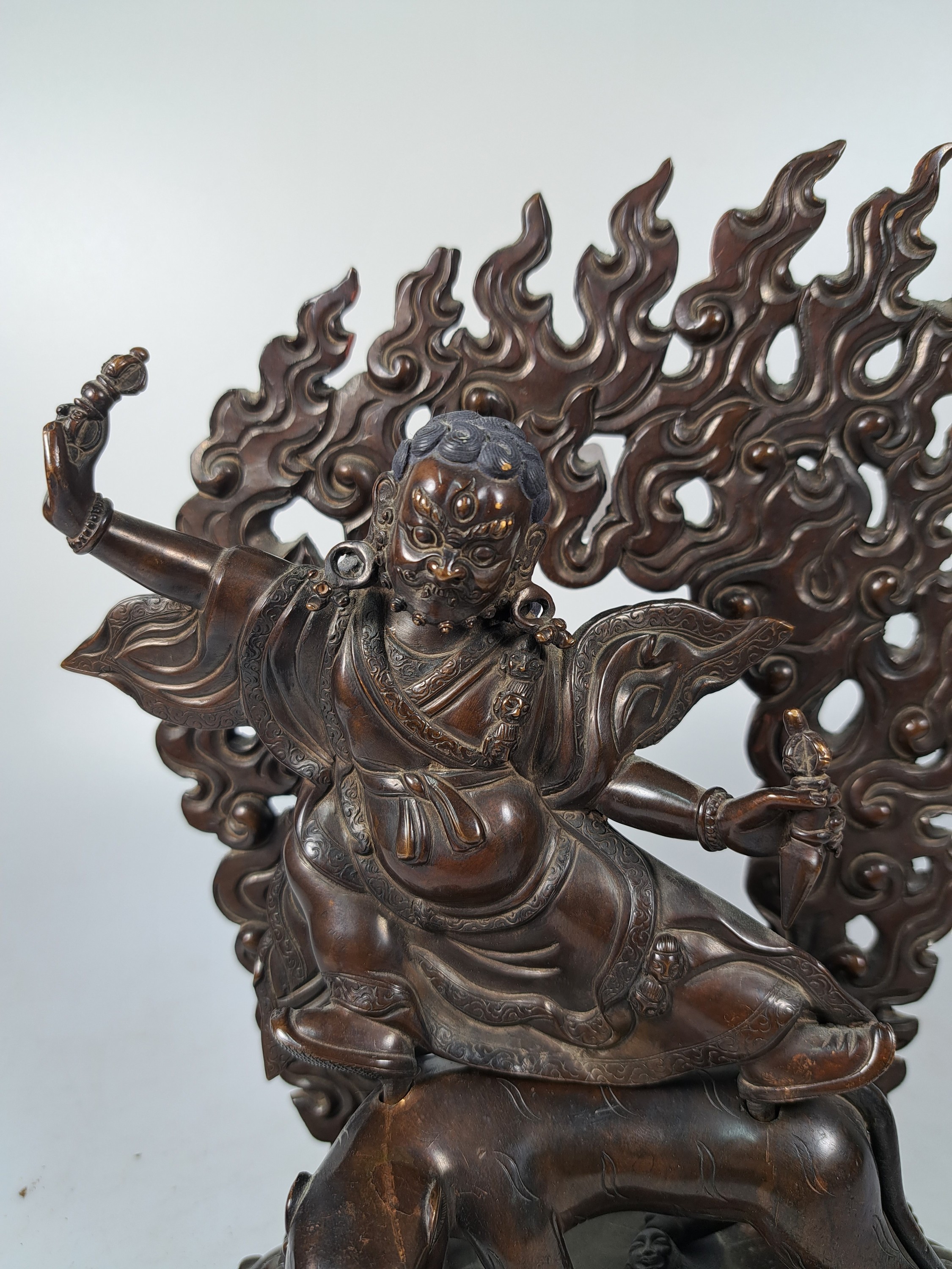 Detail b: Bronzeskulptur eines der acht Dharmapalas, Tibet/Nepal, 20.Jh., Bronze patiniert, Schutzgottheit auf einem Leoparden reitend, zuFüßen zwei ...