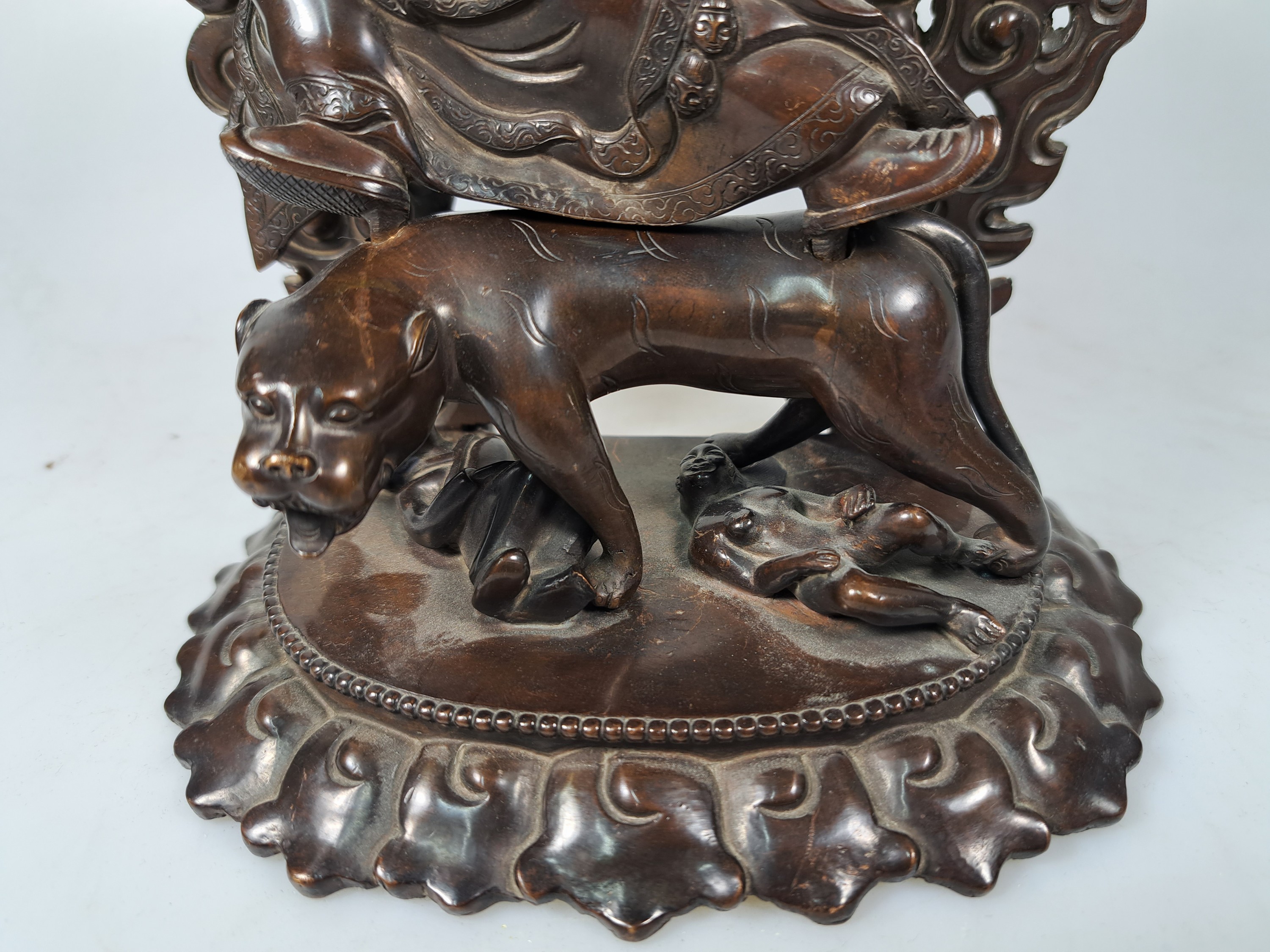 Detail c: Bronzeskulptur eines der acht Dharmapalas, Tibet/Nepal, 20.Jh., Bronze patiniert, Schutzgottheit auf einem Leoparden reitend, zuFüßen zwei ...