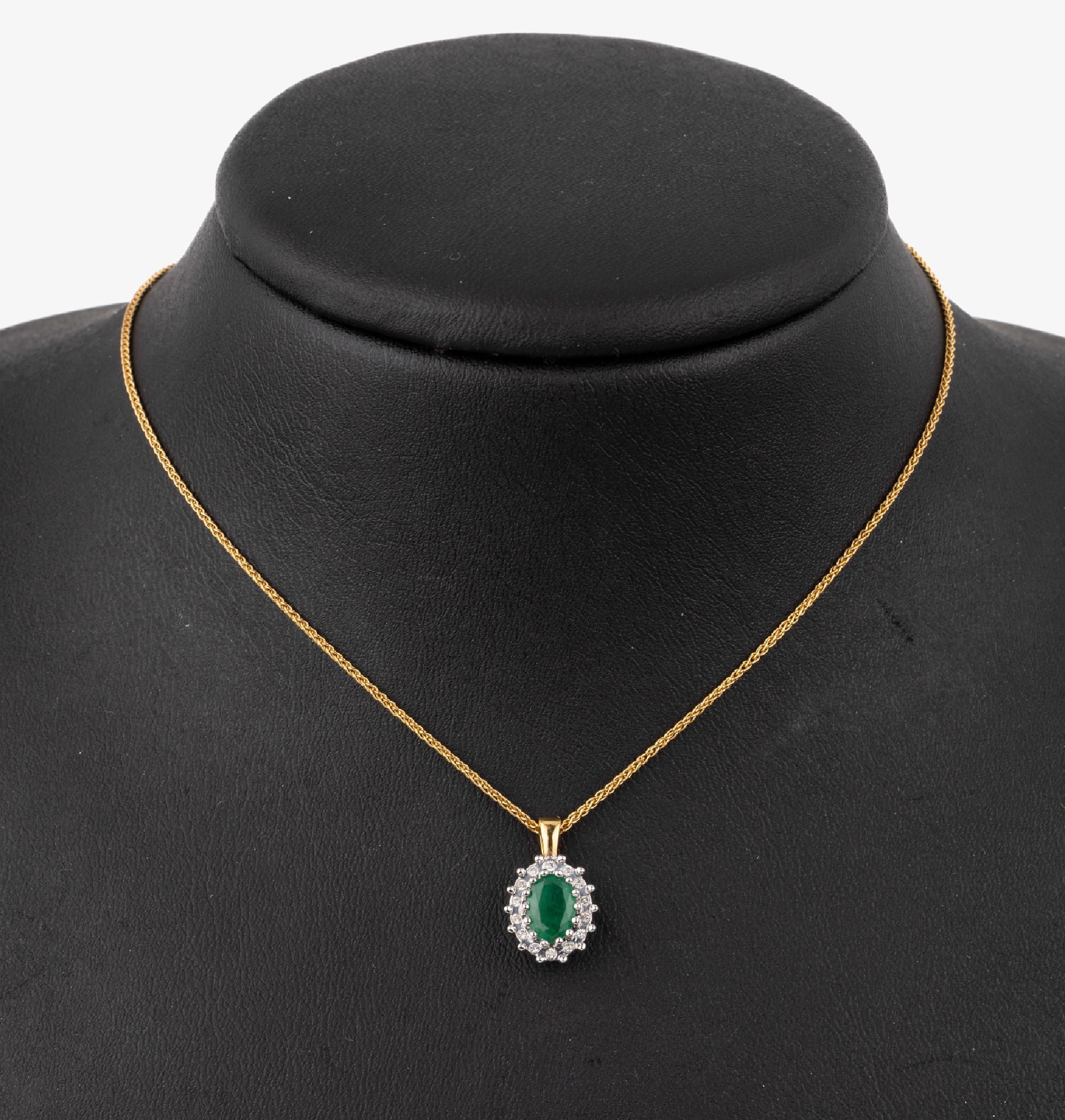 14 kt Gold Smaragd-Brillant-Anhänger, GG/WG585/000, mittig ovalfacett. Smaragd umgeben von kl. Brillanten, an Kette, GG 333/000, L. ca. 42.5 cm, ...