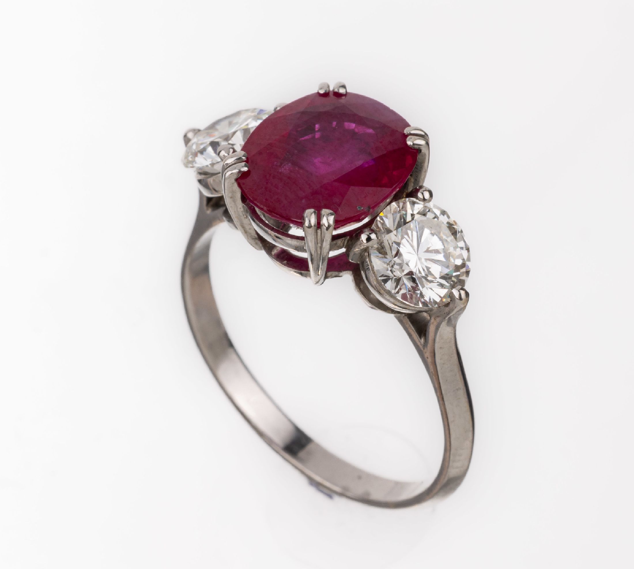 18 kt Gold Rubin-Brillant-Ring, WG 750/000 (gepr.), mittig ovalfacett. Rubin ca. 3.35 ct,umgeben von 2 Brillanten zus. ca. 1.50 ct l.get.Weiß/vs, ...