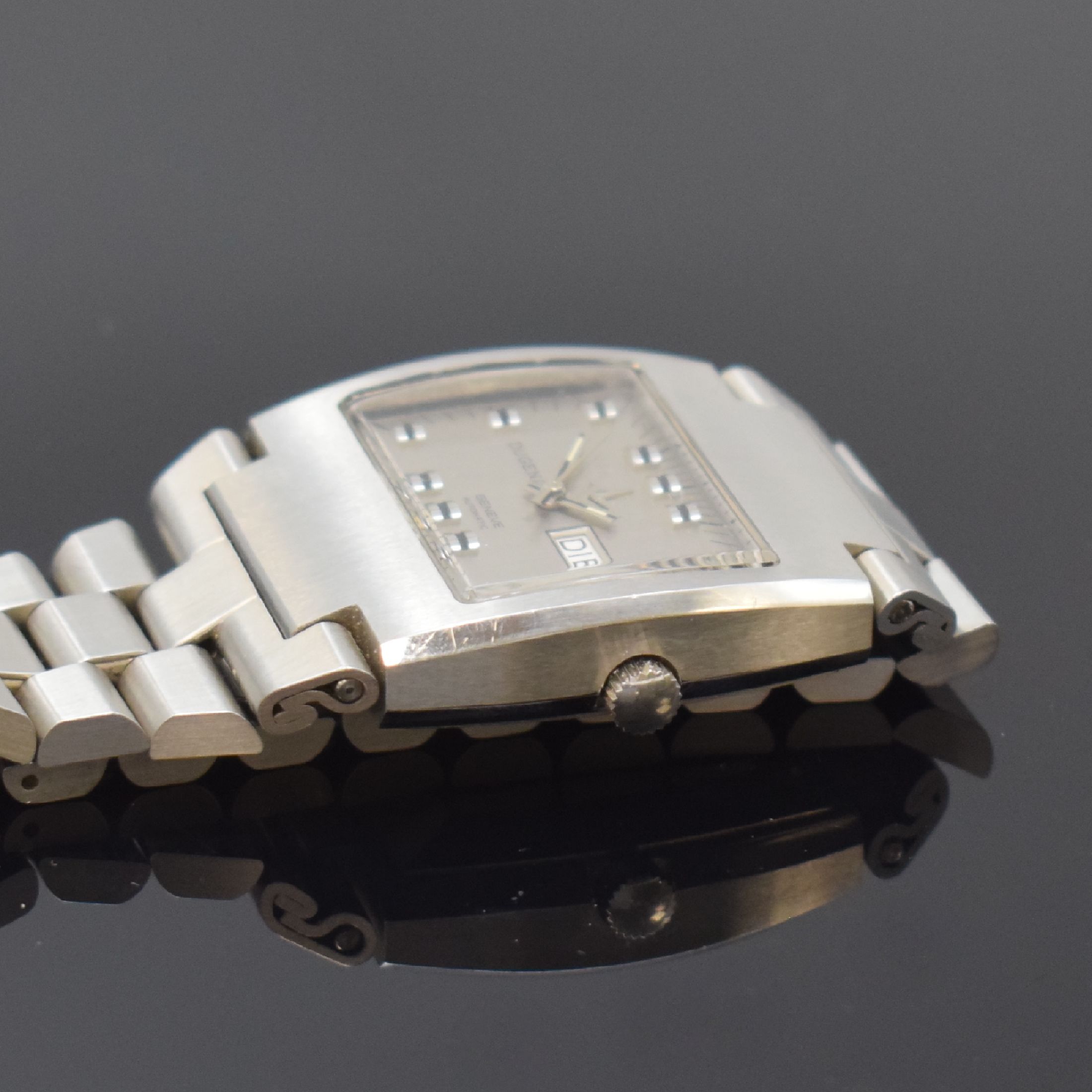 Detail b: DUGENA Herrenarmbanduhr in Edelstahl, Automatik, Schweiz um 1970, massives Edelstahlgeh. inkl. integriertem Gliederband m. Faltschl., silb. Zifferbl. ...