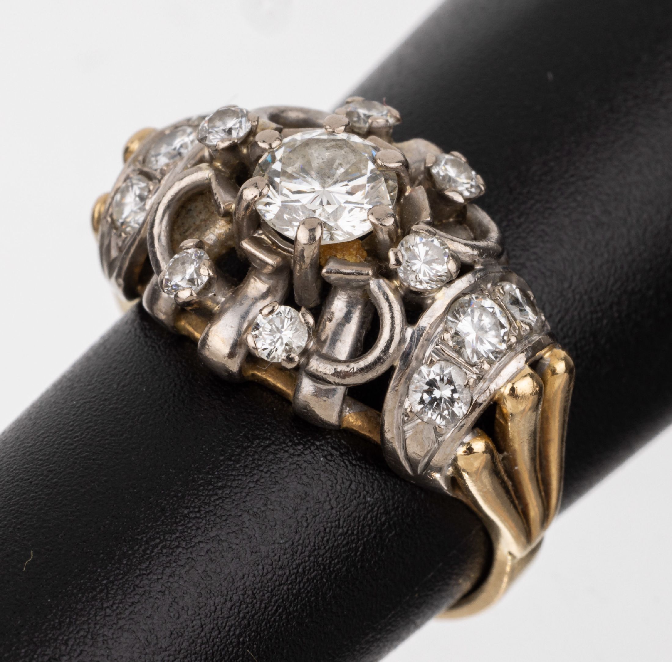 18 kt Gold Brillant-Ring, um 1930, GG/WG 750/000, durchbrochen gearbeitet, Ringschultern gerillt, mittiger Brillant ca. 0.65 ct Weiß/vs, umgeben ...